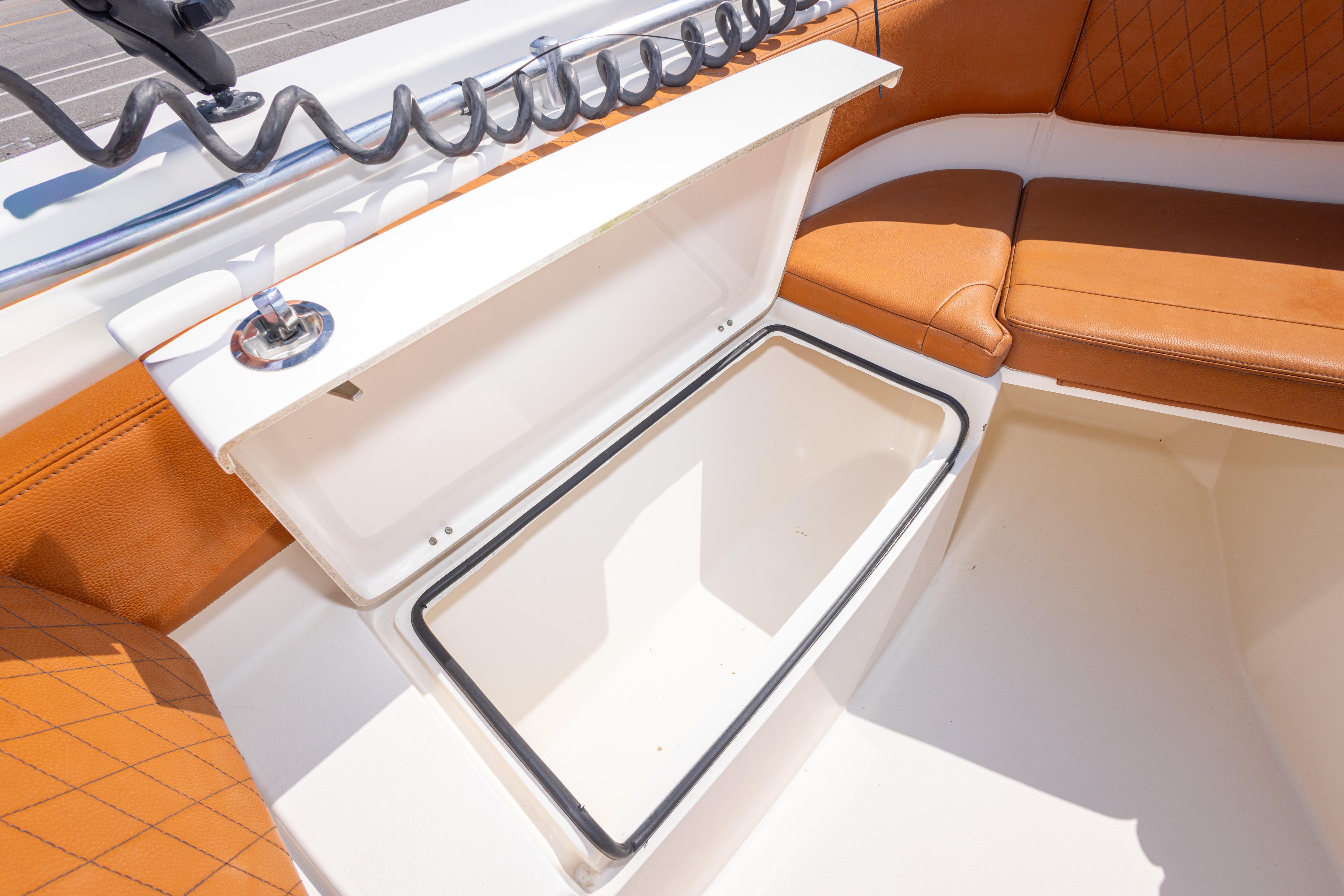 2017 Cobia 261 Center Console boat with open storage compartment and cushioned seating.