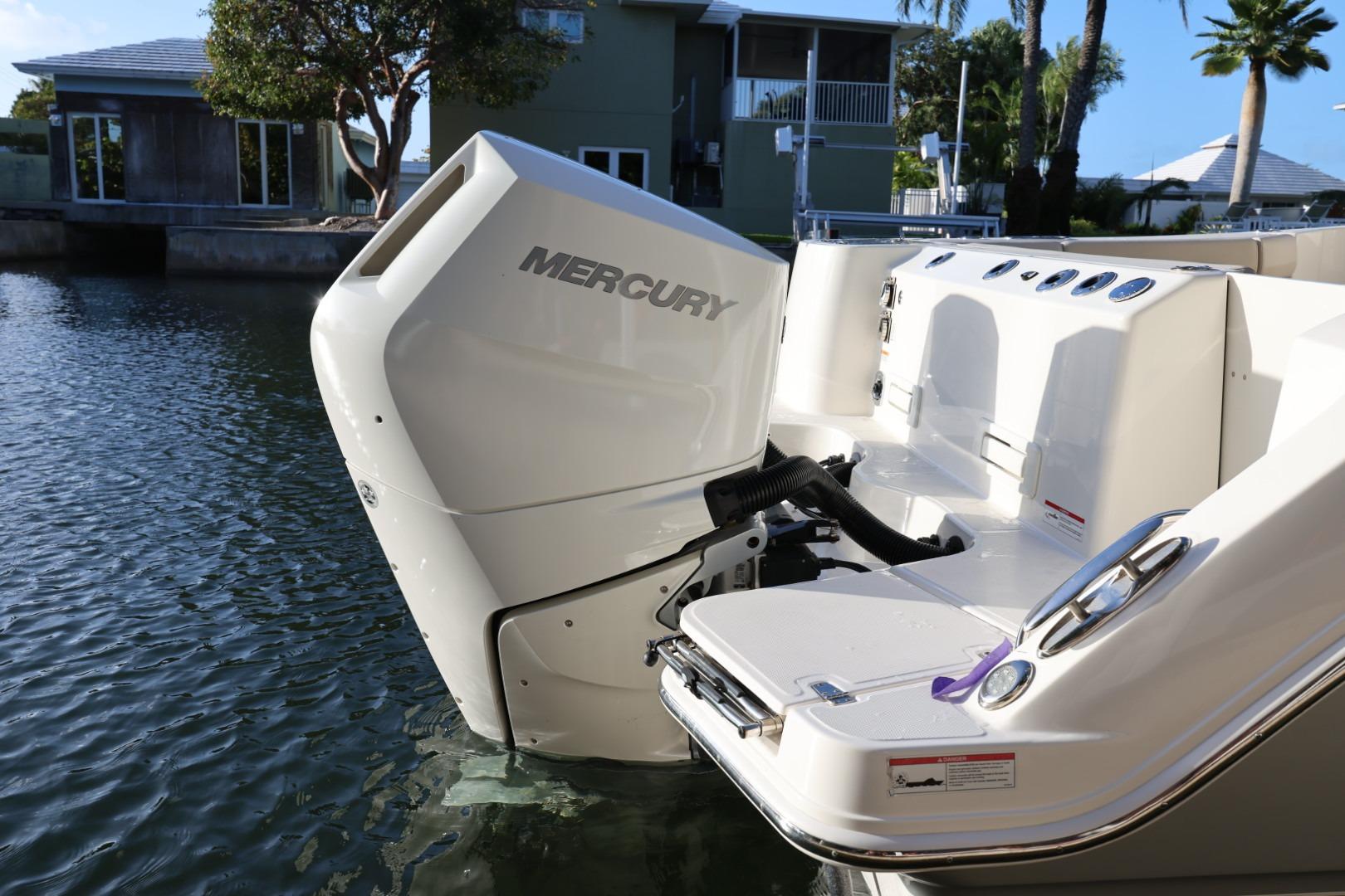 2025 Boston Whaler 325 Conquest with Mercury engine, docked by waterfront homes.