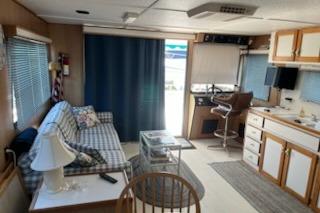 Interior of a 1994 PlayCraft 5215 houseboat with cozy seating and kitchenette.