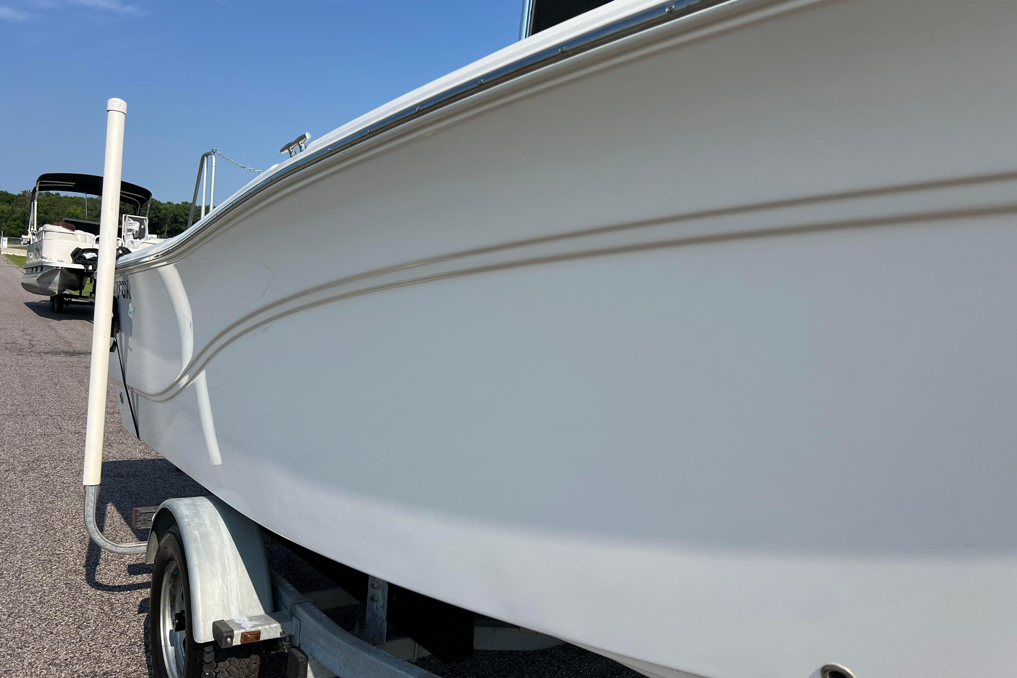 2012 Sea Fox 206 Center Console boat on trailer, side view under clear sky.