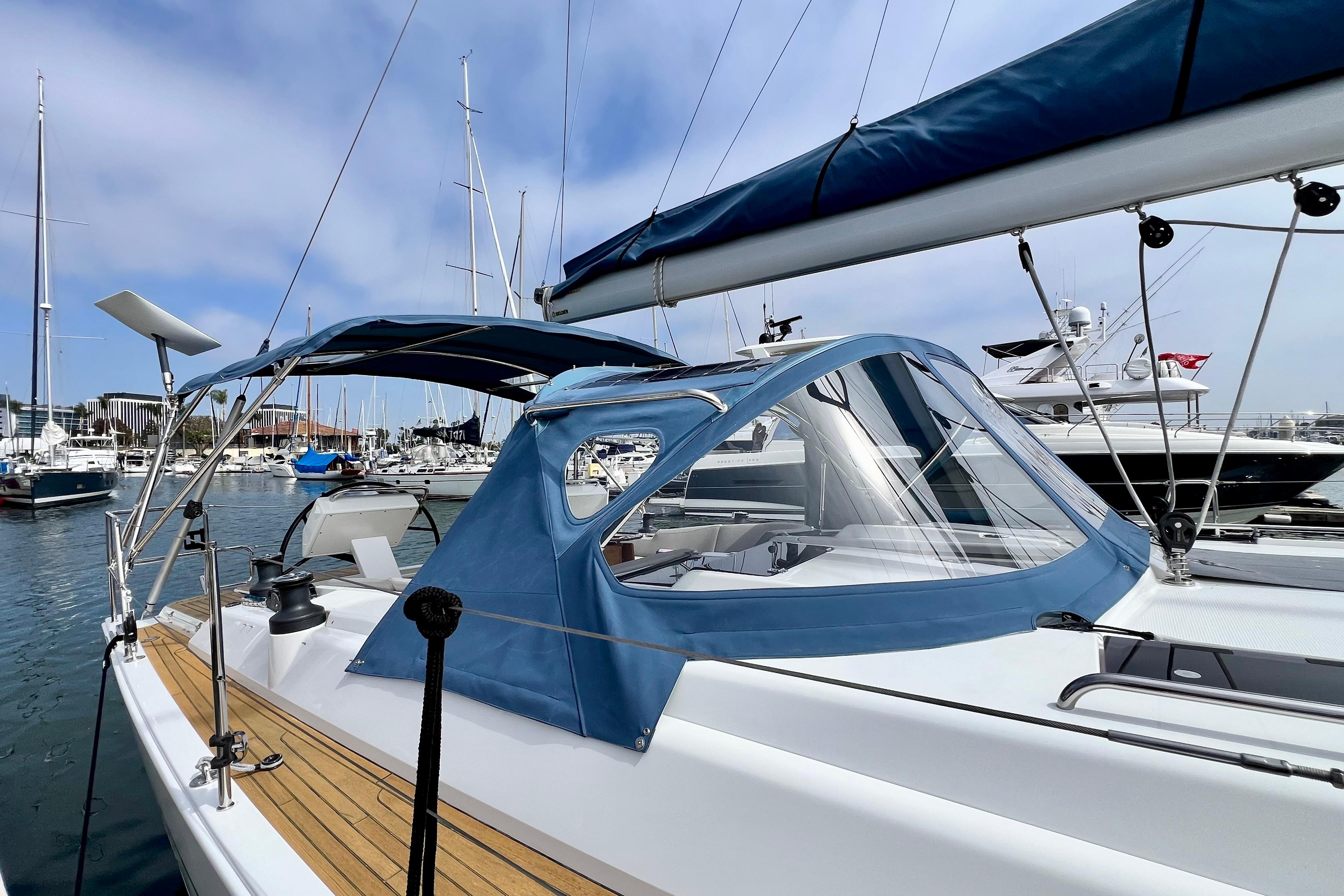 2016 Hanse 455 sailboat docked in marina, featuring blue canopy and sleek design.