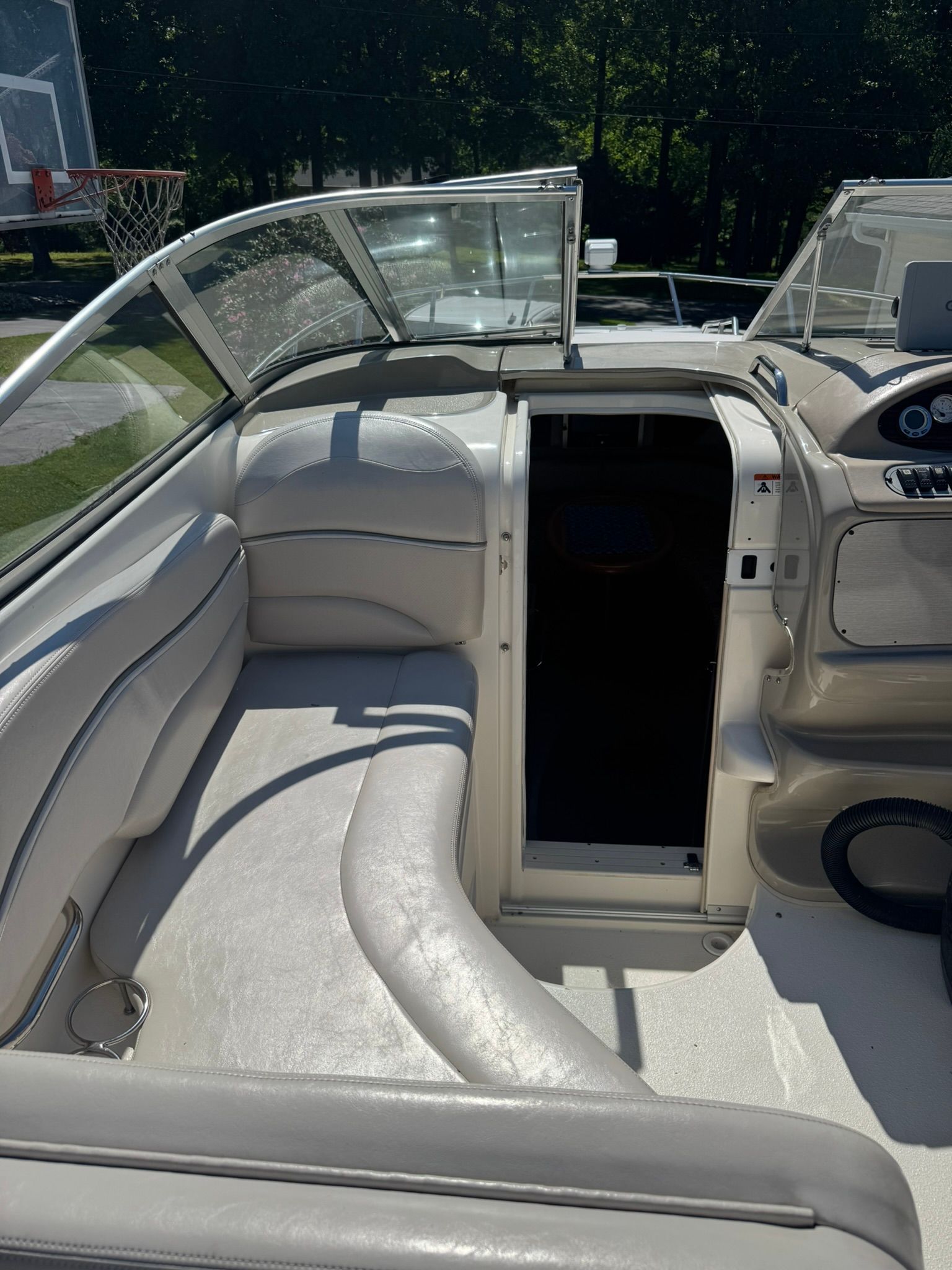 The boat features white leather seating and an open cockpit with clear windows.