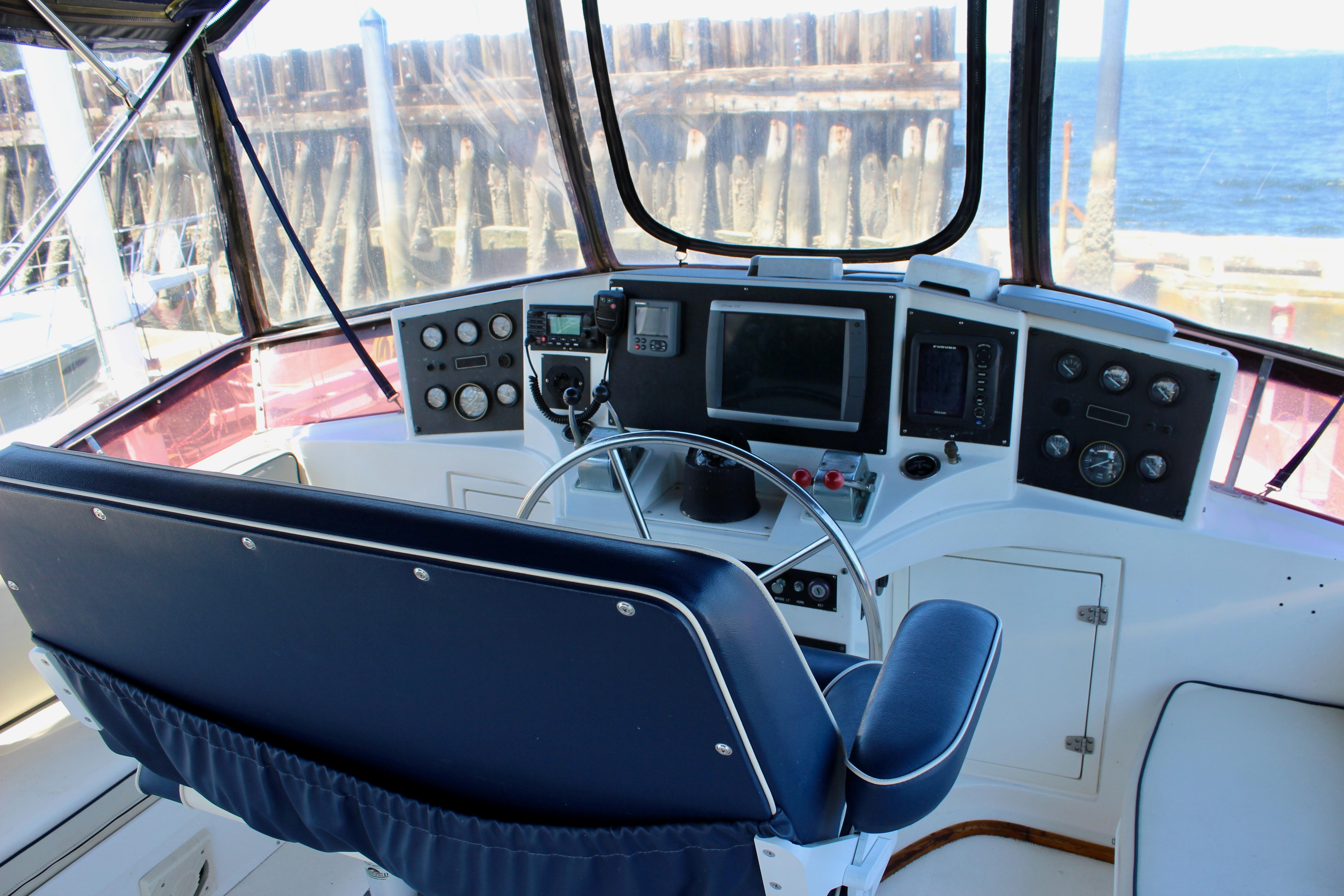 Helm of 1986 Kha Shing Spindrift 46 yacht with navigation instruments and blue seating.