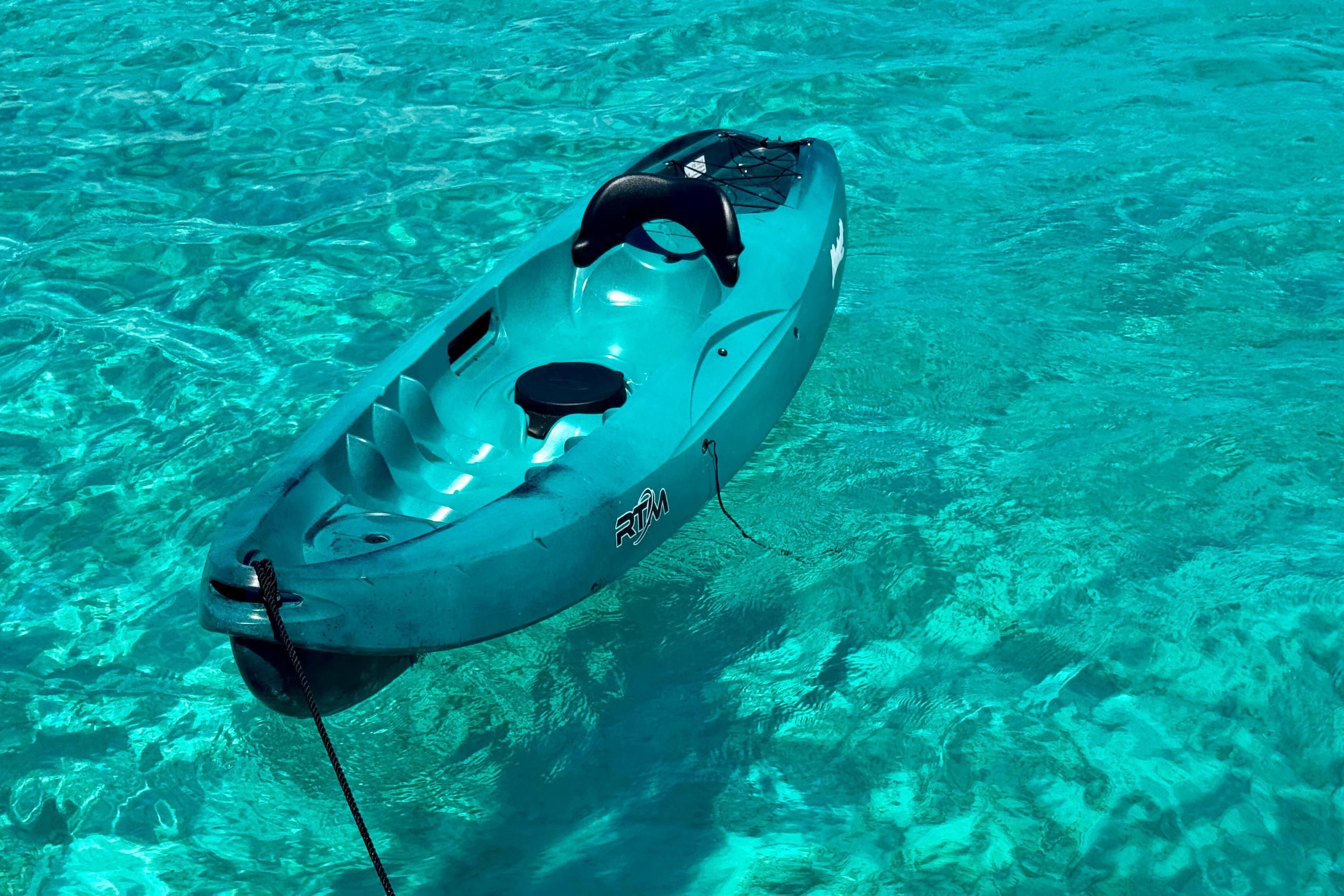 Turquoise kayak floating on clear blue water, near a 2020 Fountaine Pajot Saona 47.