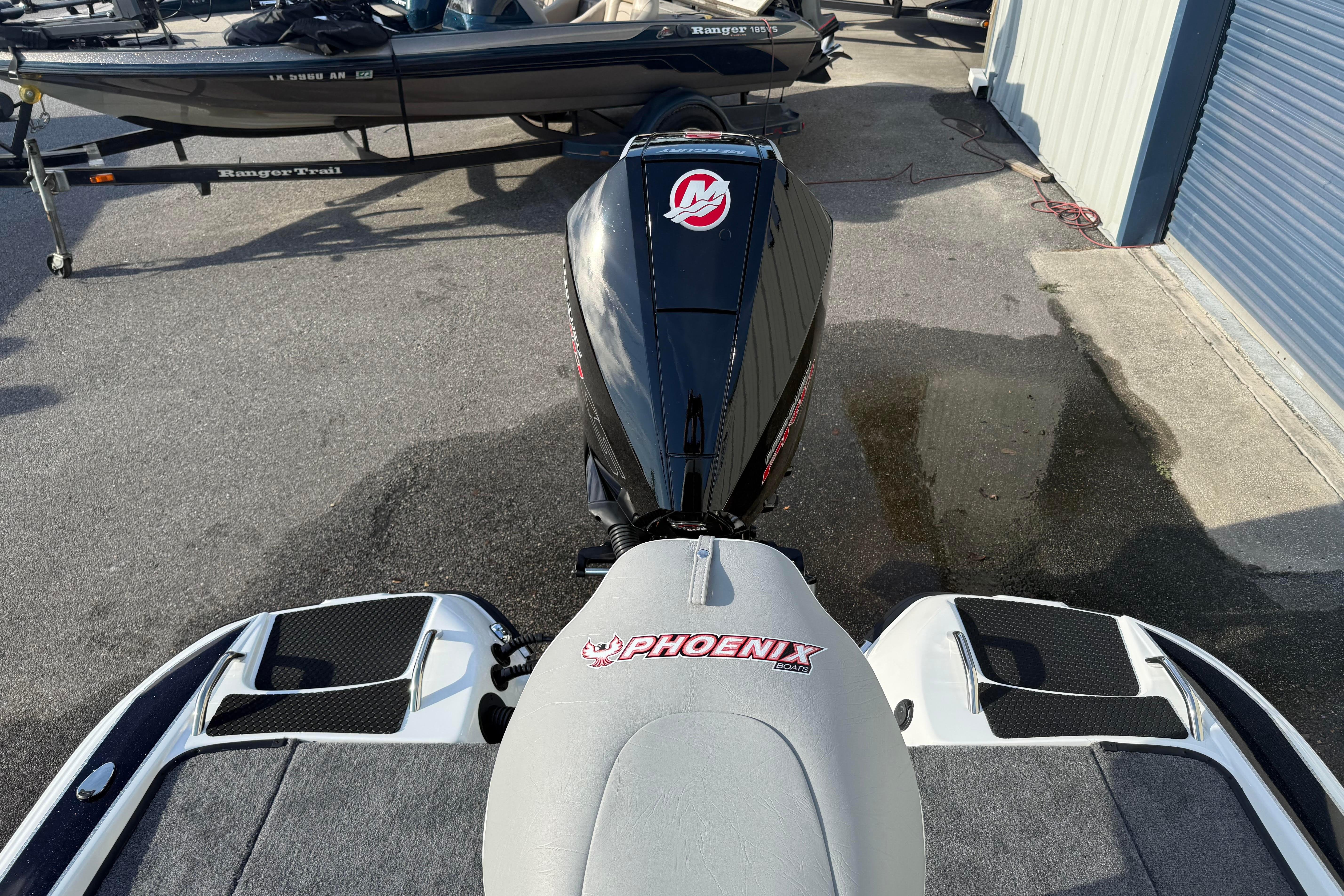 2027 Phoenix 721 ZXL boat with powerful outboard motor, parked on concrete surface.