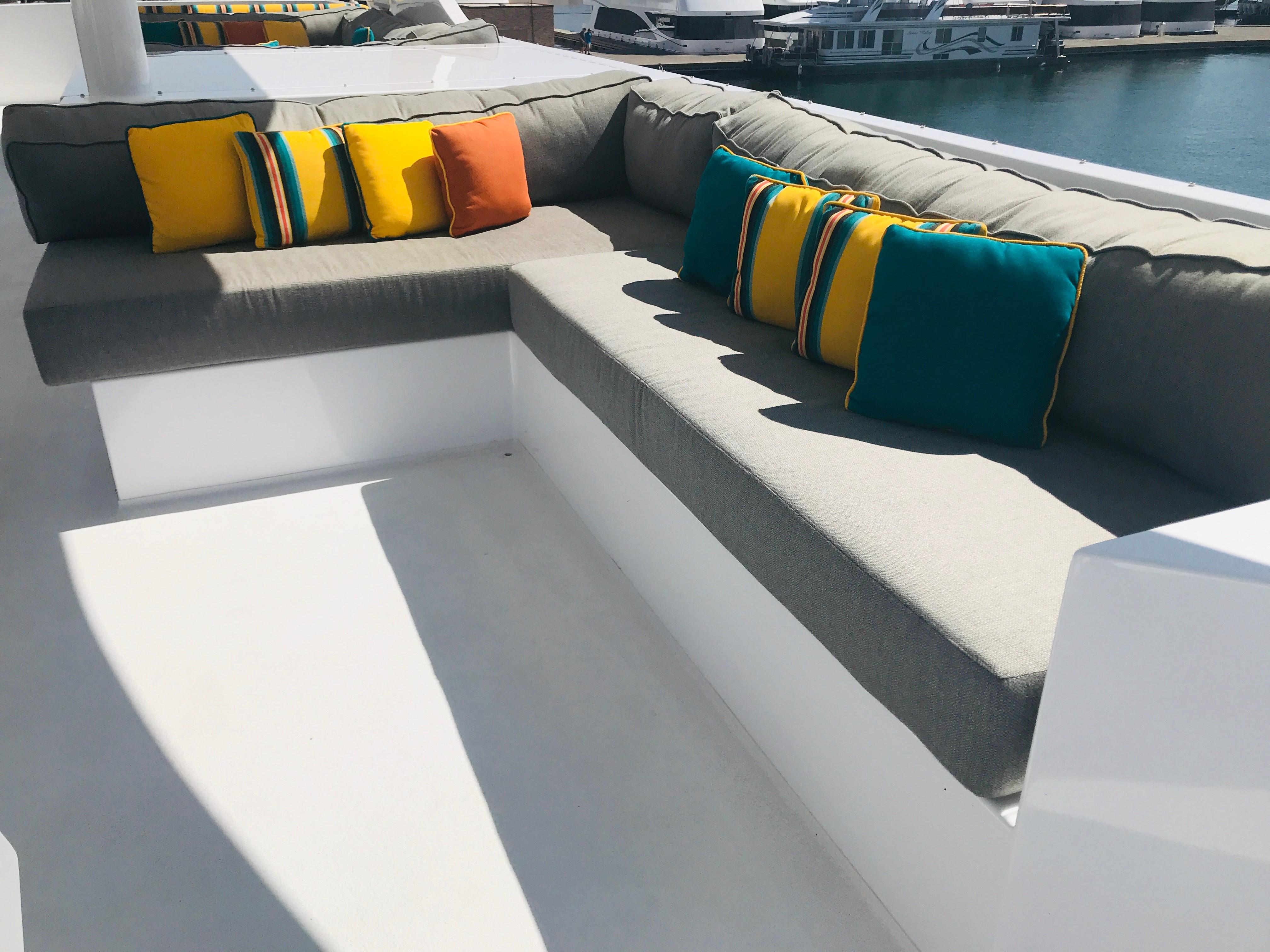 Luxurious Adonia Adonis Trip 3 yacht seating with colorful cushions, docked at marina.