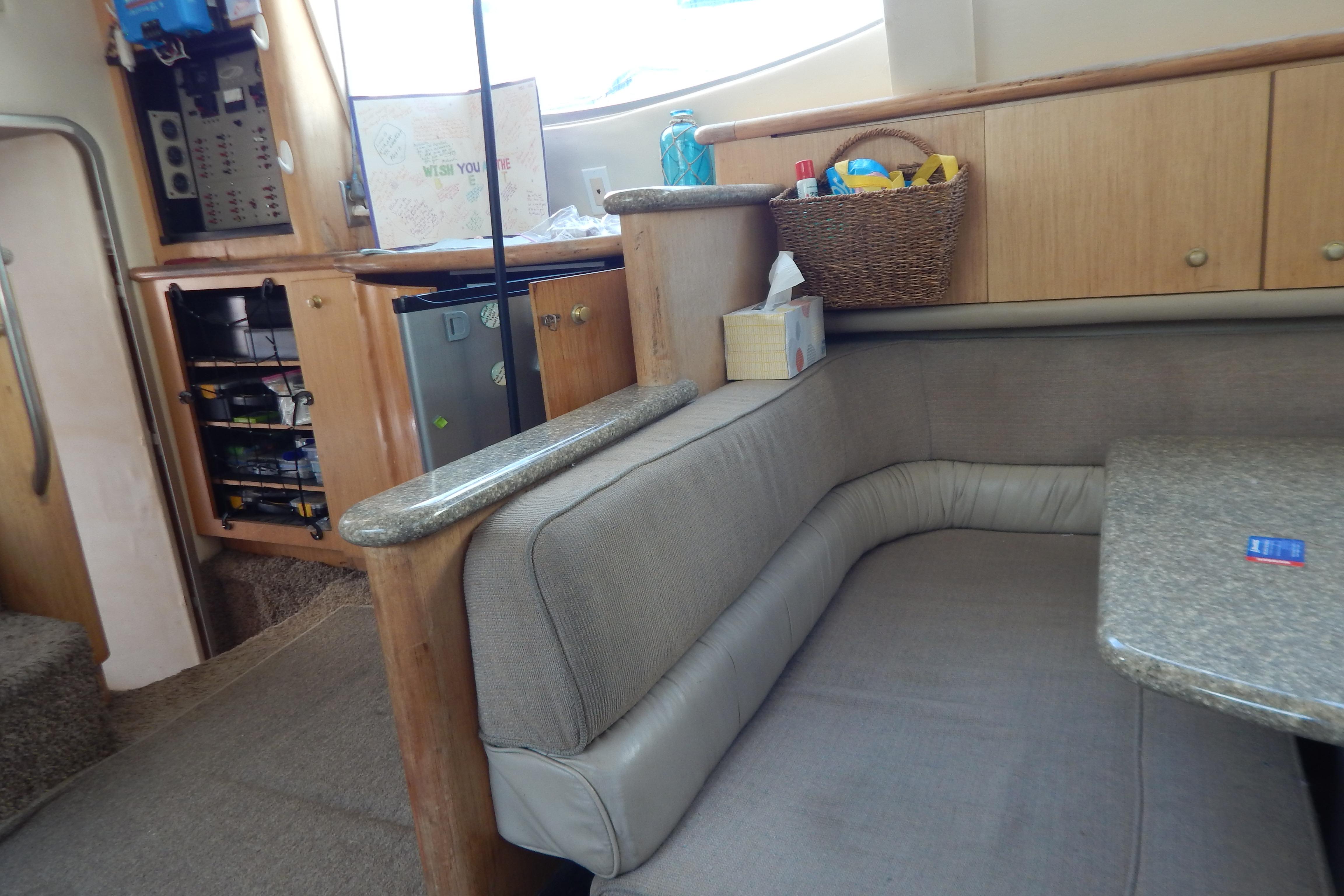 Interior of a 1998 Magnum 4100 SCR yacht with cozy seating and wooden cabinetry.