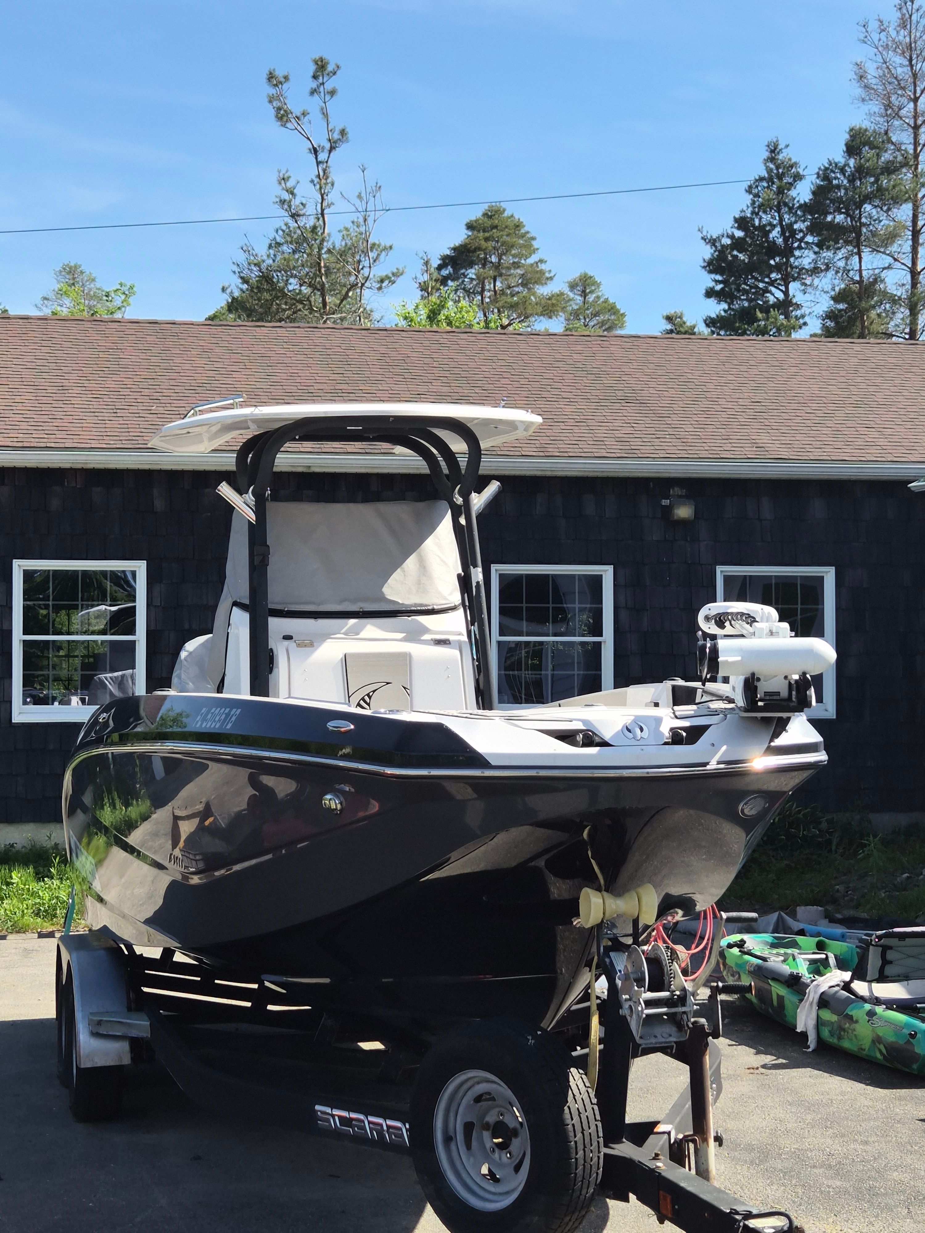 2019 Scarab 255 Open ID boat on trailer in front of building.