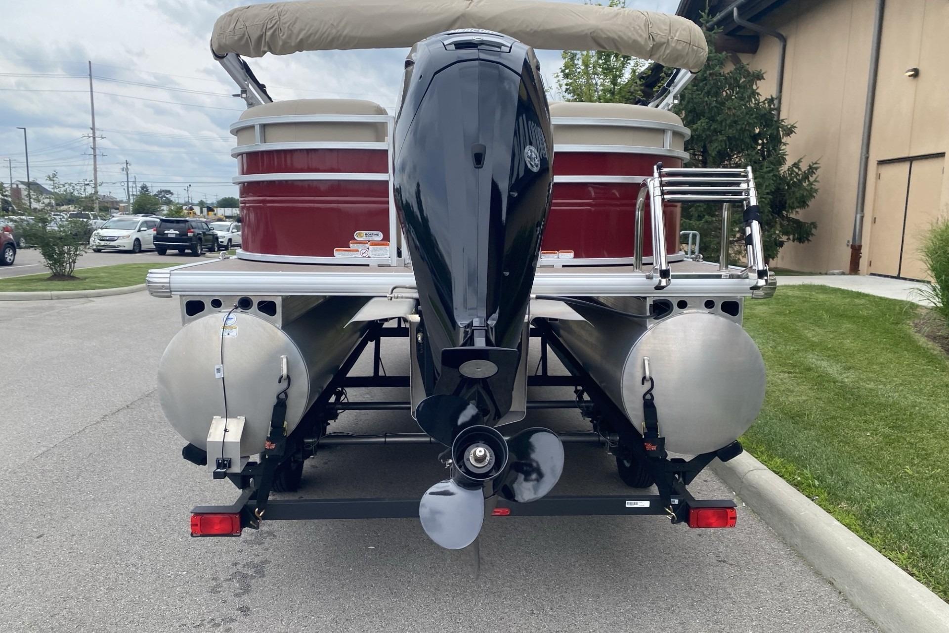 2024 Sun Tracker Party Barge 22 DLX pontoon boat, rear view with motor and trailer.