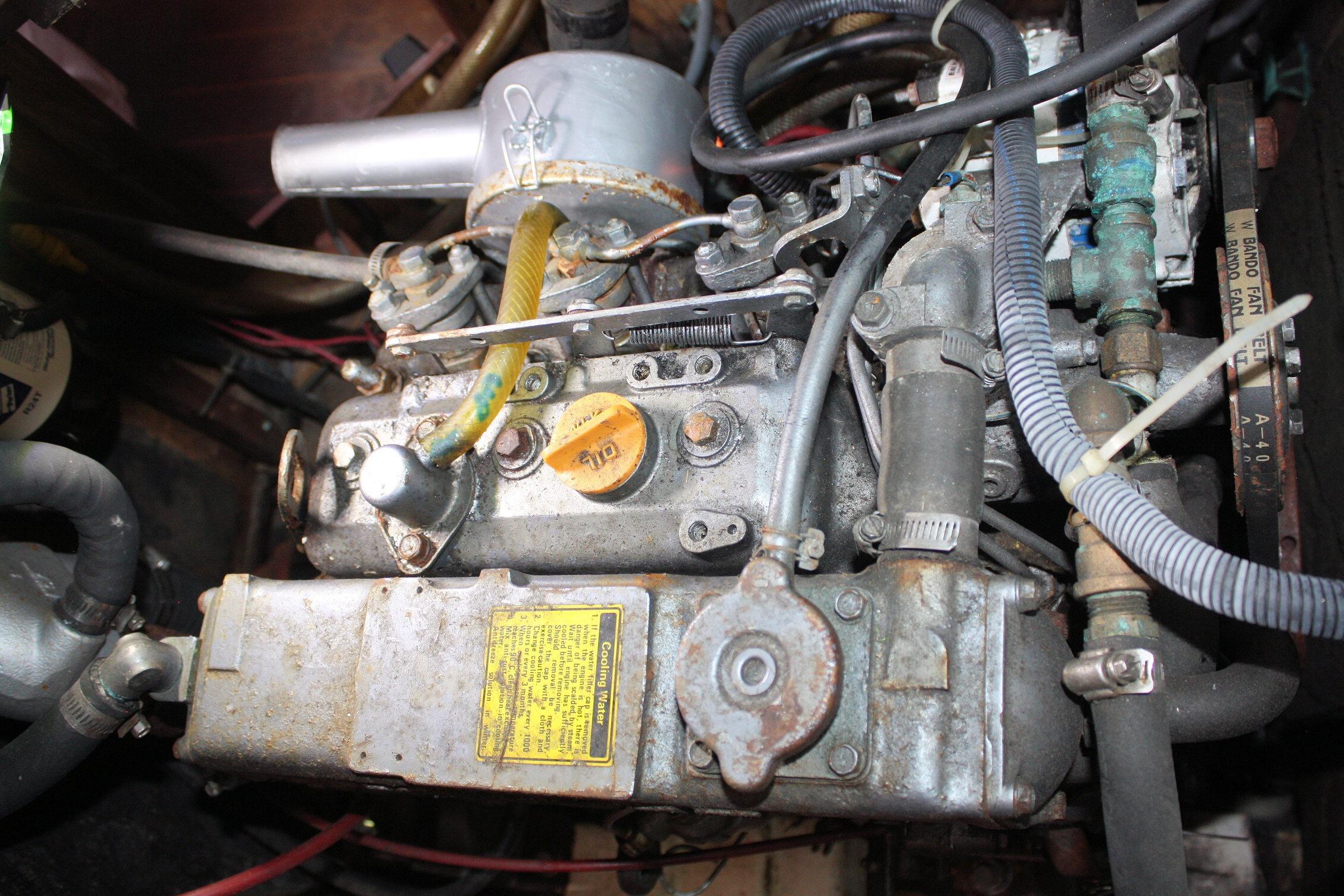 Engine of a 1987 Ericson 38-200 sailboat, showcasing mechanical components and hoses.
