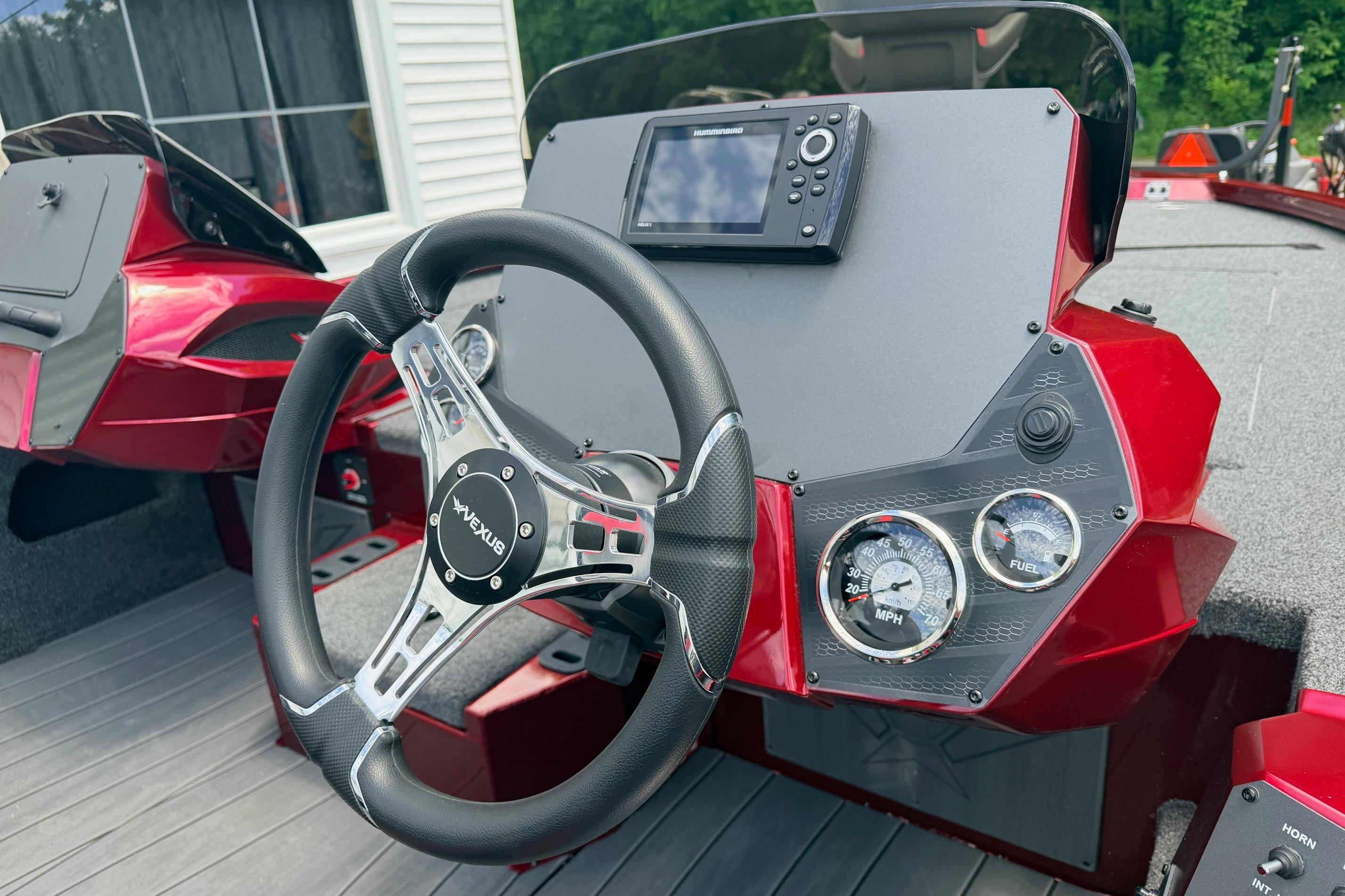 Steering console of 2026 Vexus AVX1985s boat with gauges and navigation system.