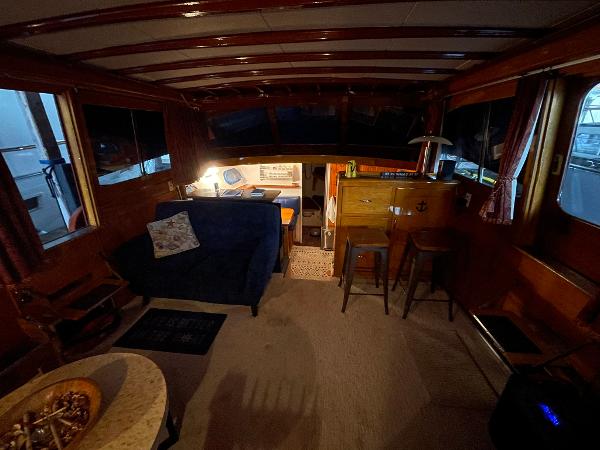 Interior of a 1951 Chris-Craft Catalina boat with cozy seating and wooden decor.