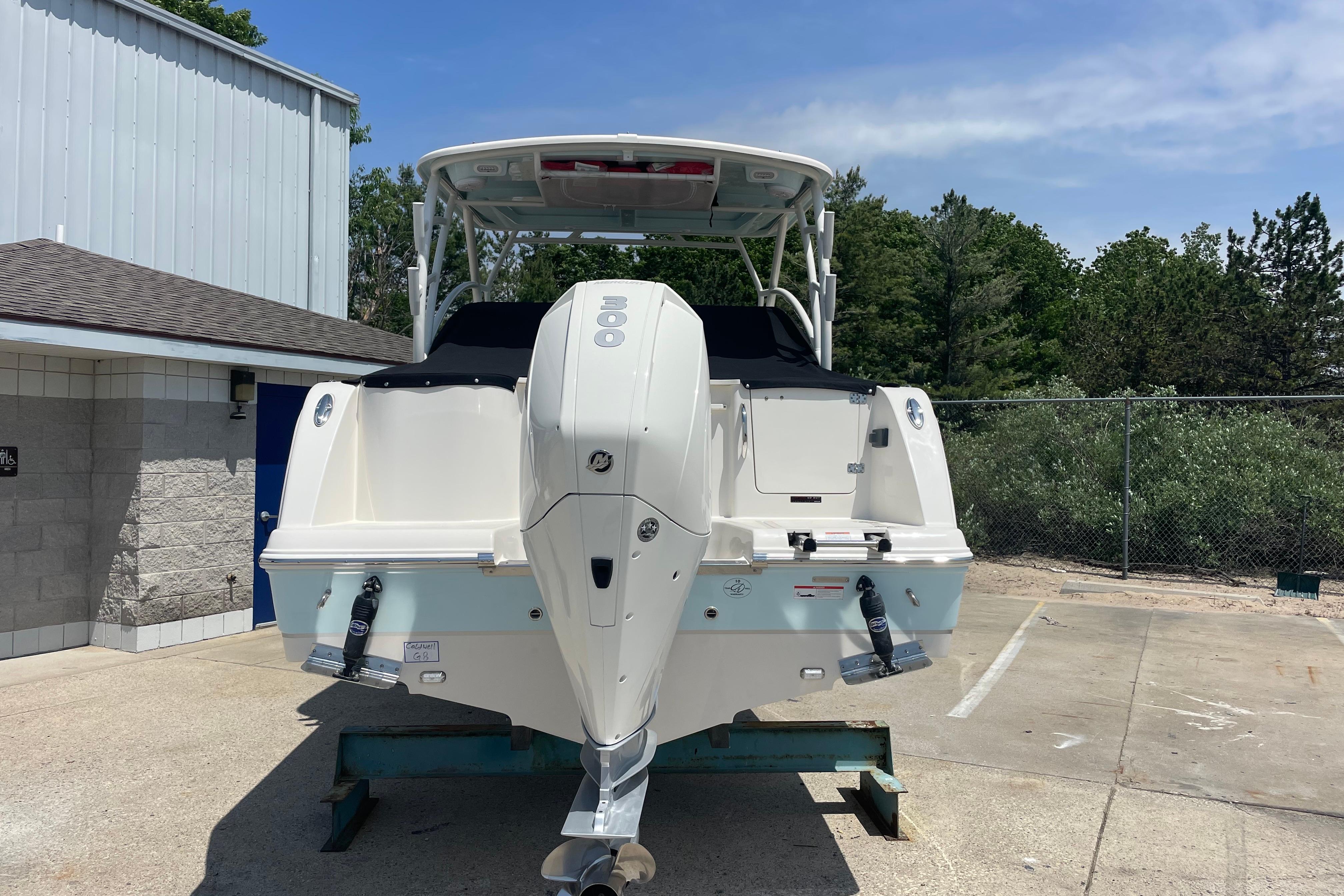 2022 Sailfish 245 DC boat with outboard motor, parked outdoors on a sunny day.