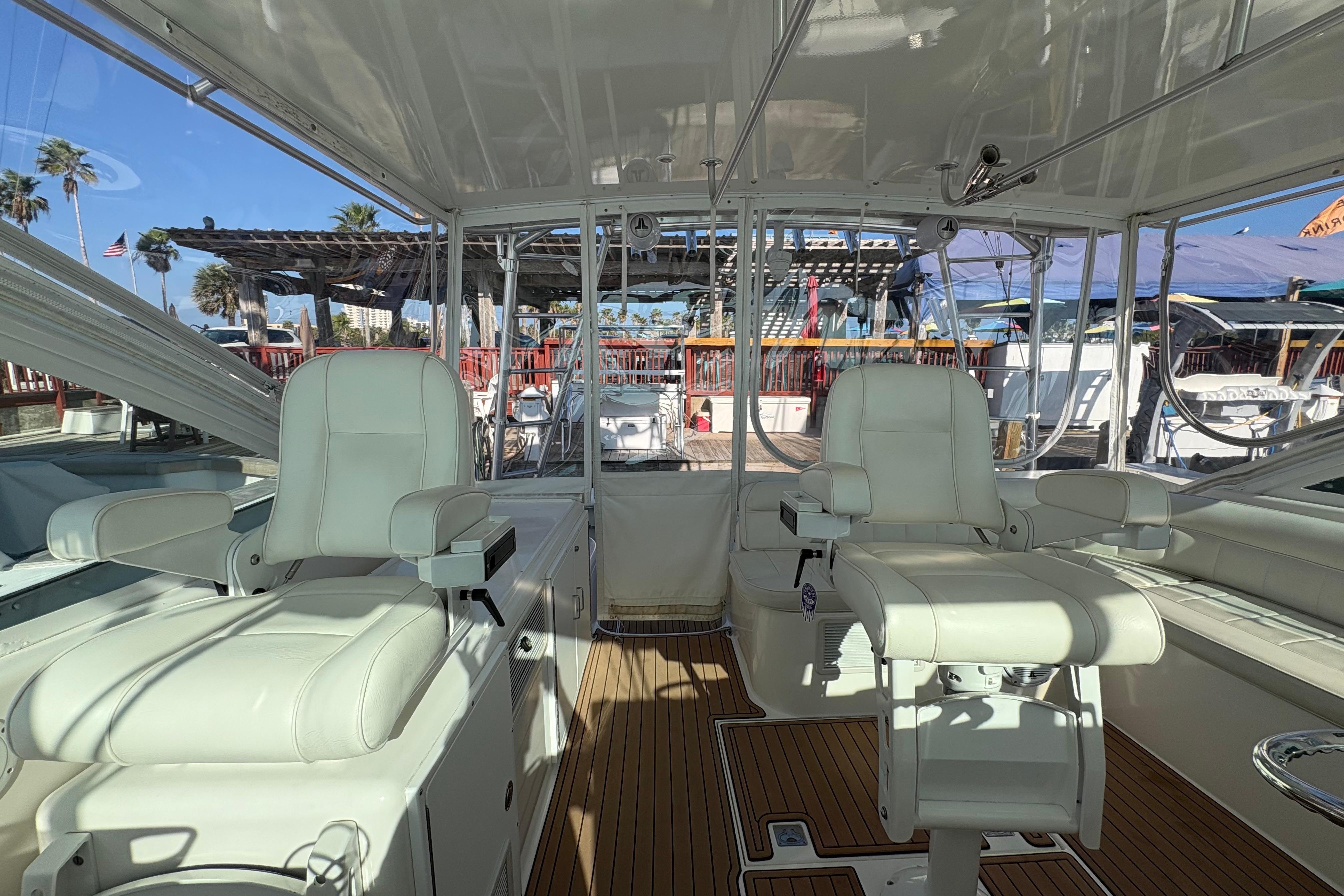 Interior of 2004 Cabo 40 Hardtop Express yacht with white seating and wooden flooring.