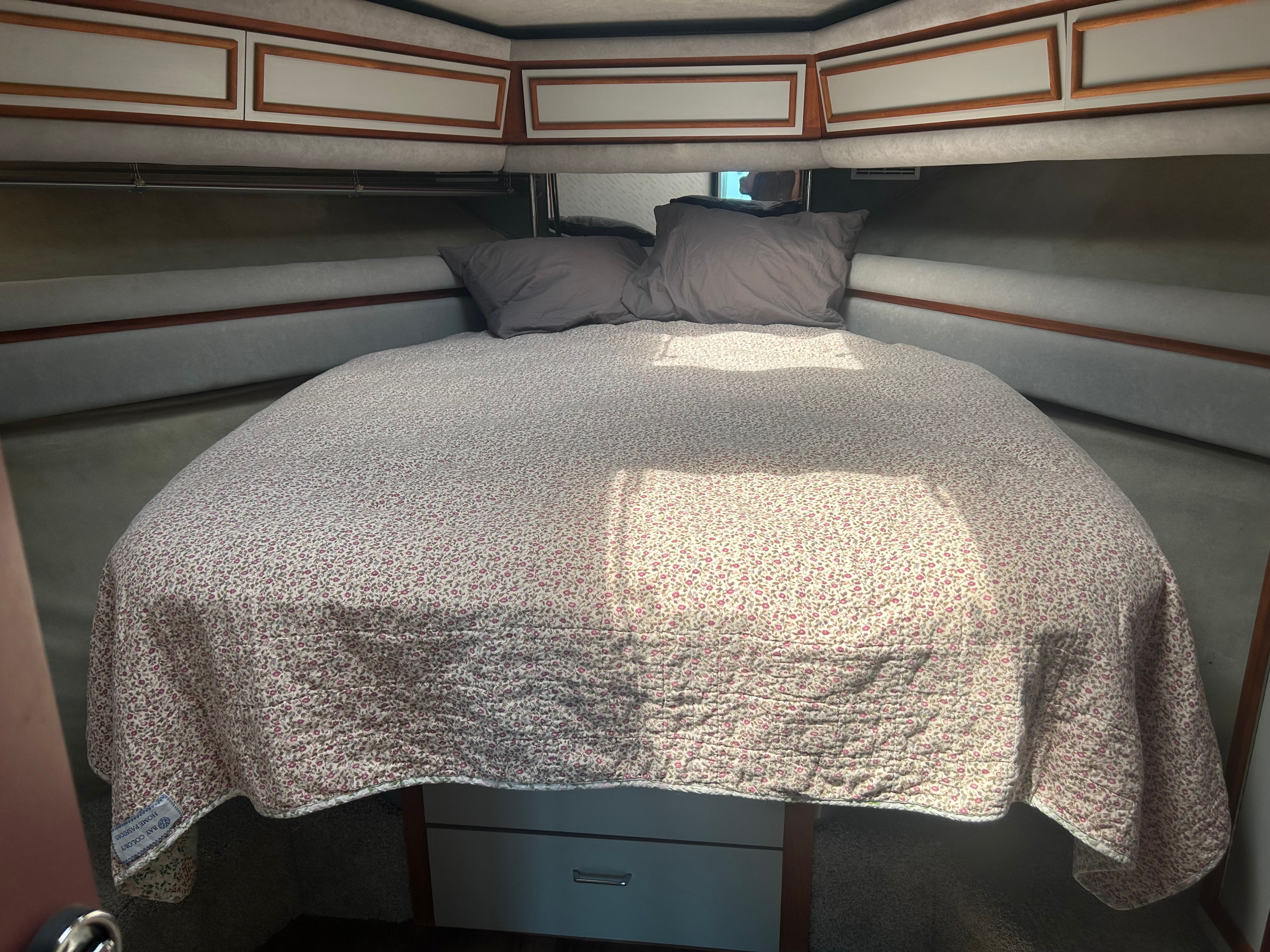 The image shows a cozy cabin with a large bed and two pillows.