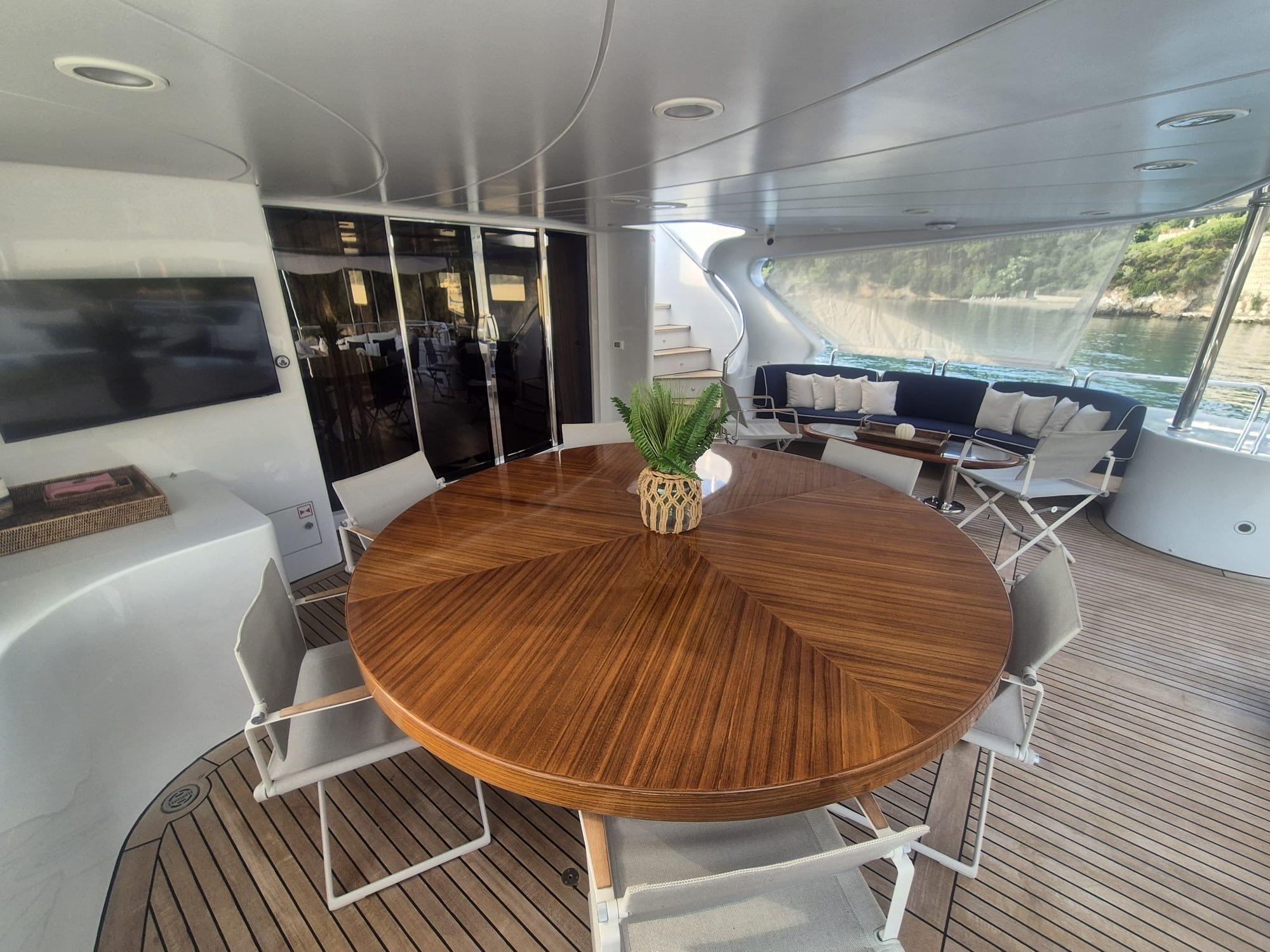 Luxurious Benetti Classic 115 yacht deck with elegant wooden table and seating, 2000 model.