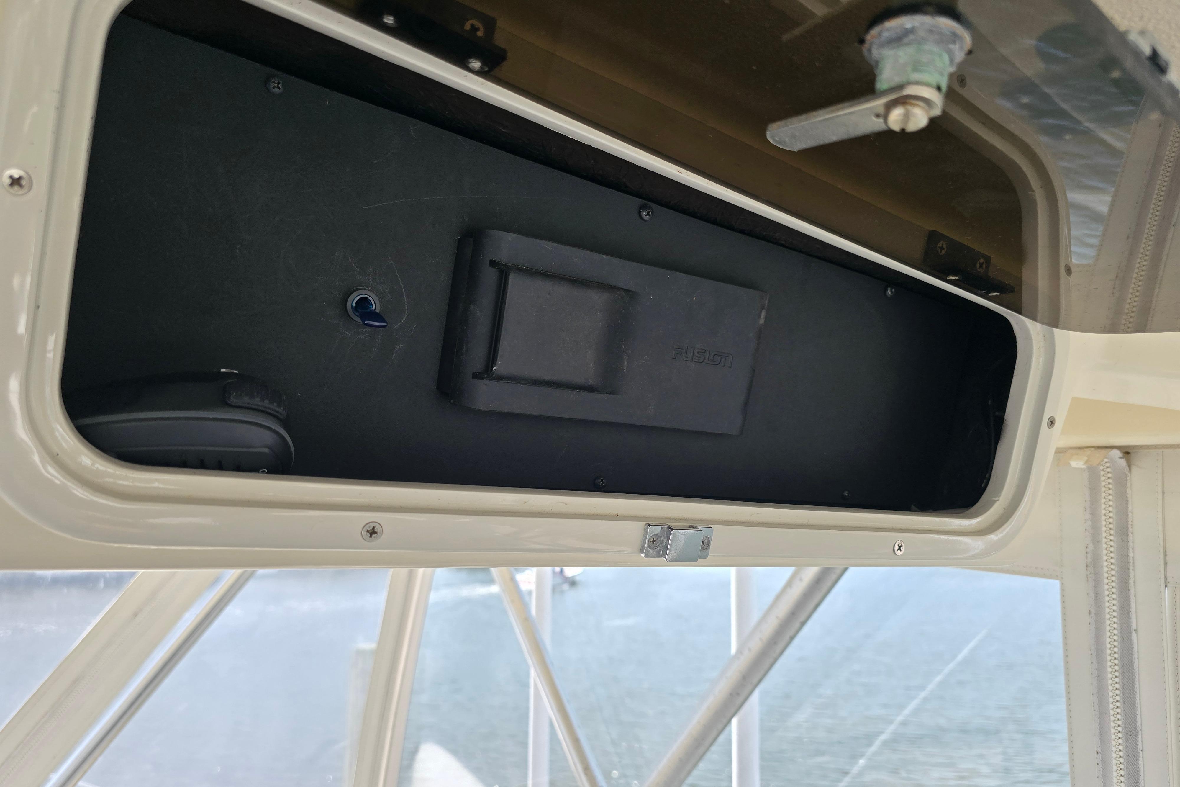 Open storage compartment in 1988 Post 46 Convertible boat, featuring a Fusion audio system.