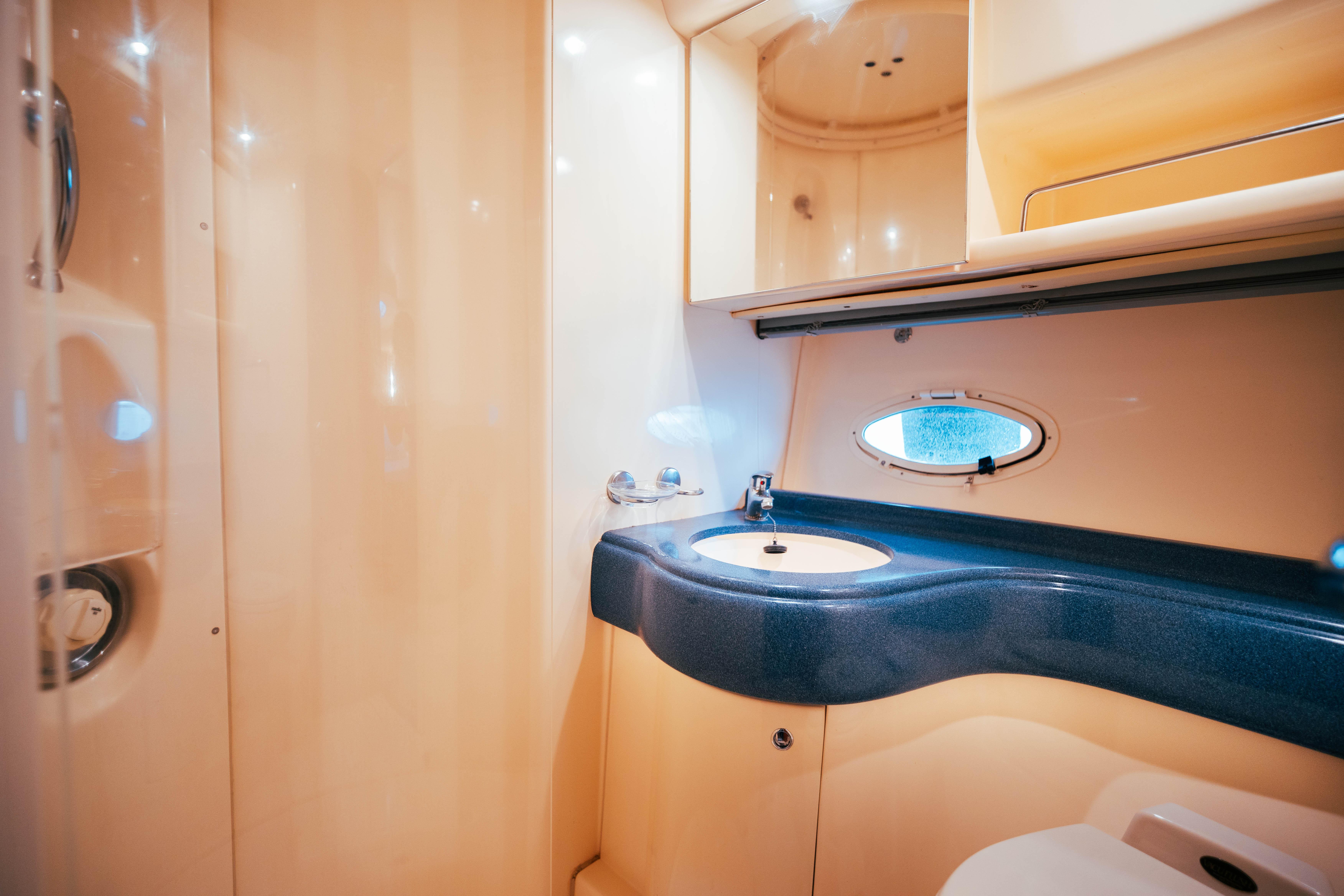 2003 Azimut 42 yacht bathroom with modern sink and porthole window.