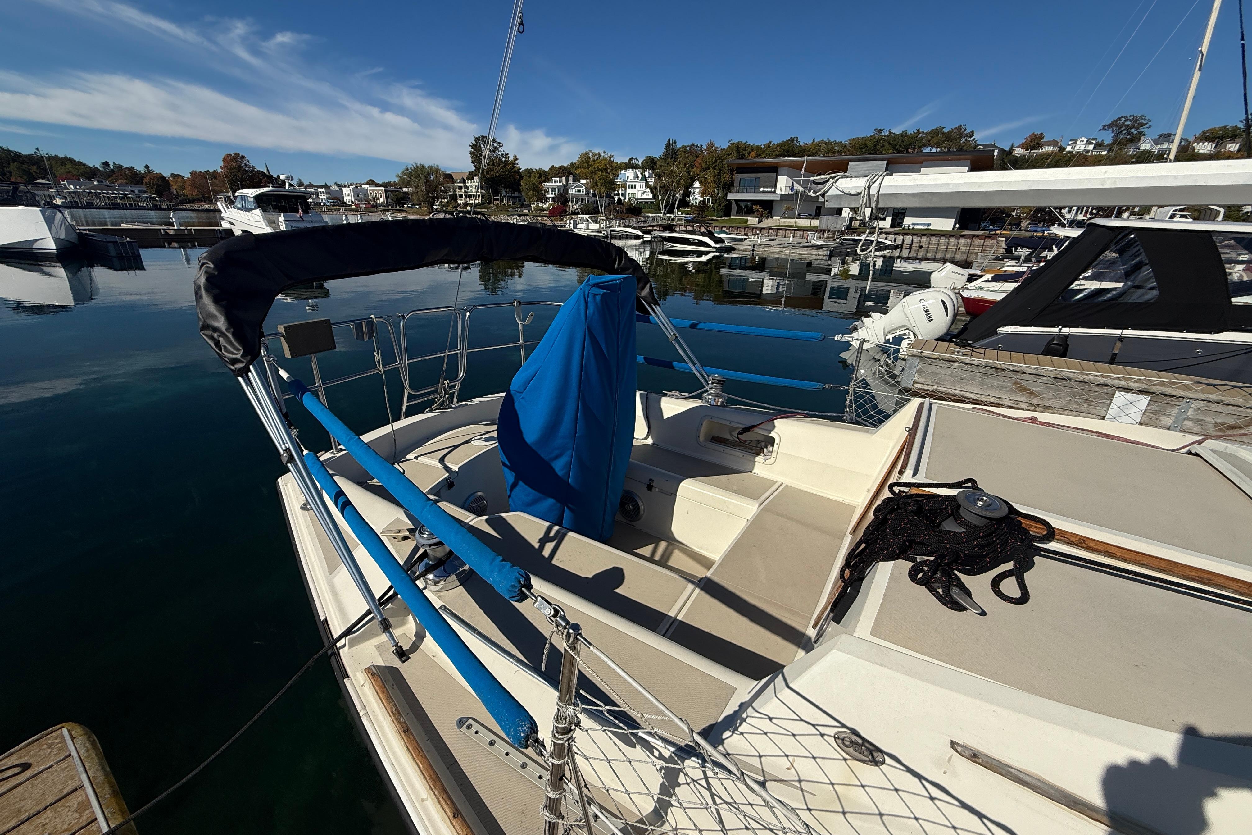 1983 O'Day 34 sailboat docked at a marina under clear blue skies.