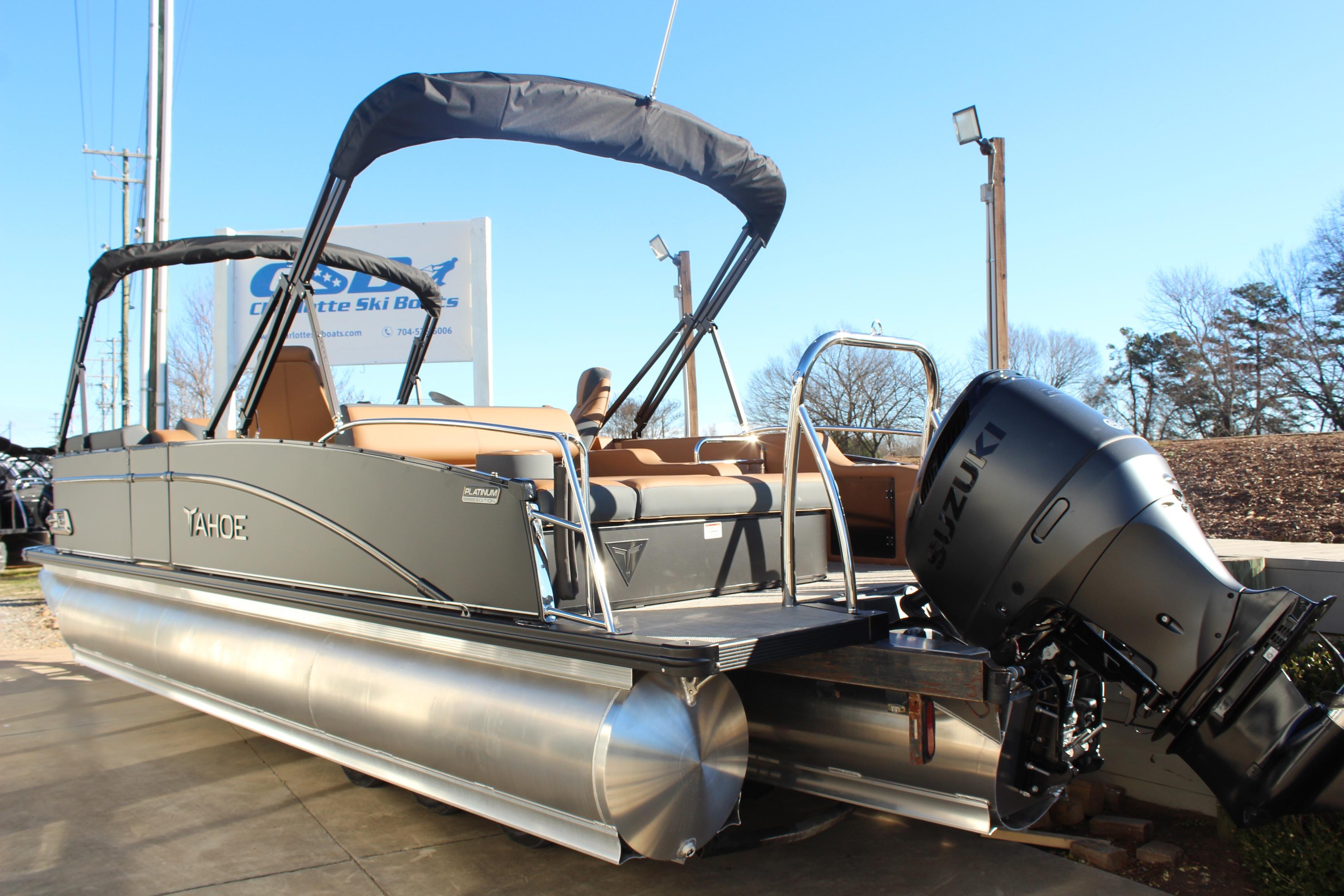 2026 Tahoe Pontoon Cascade Versatile Rear Bench with Suzuki outboard motor, docked outdoors.