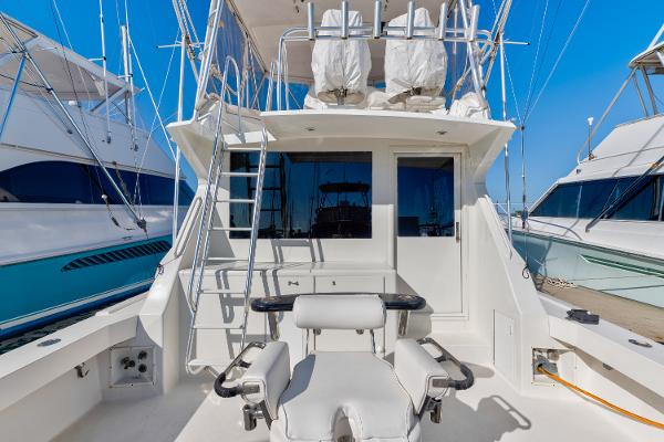 1999 Viking 47 Convertible yacht with fishing chair and ladder, docked at marina.