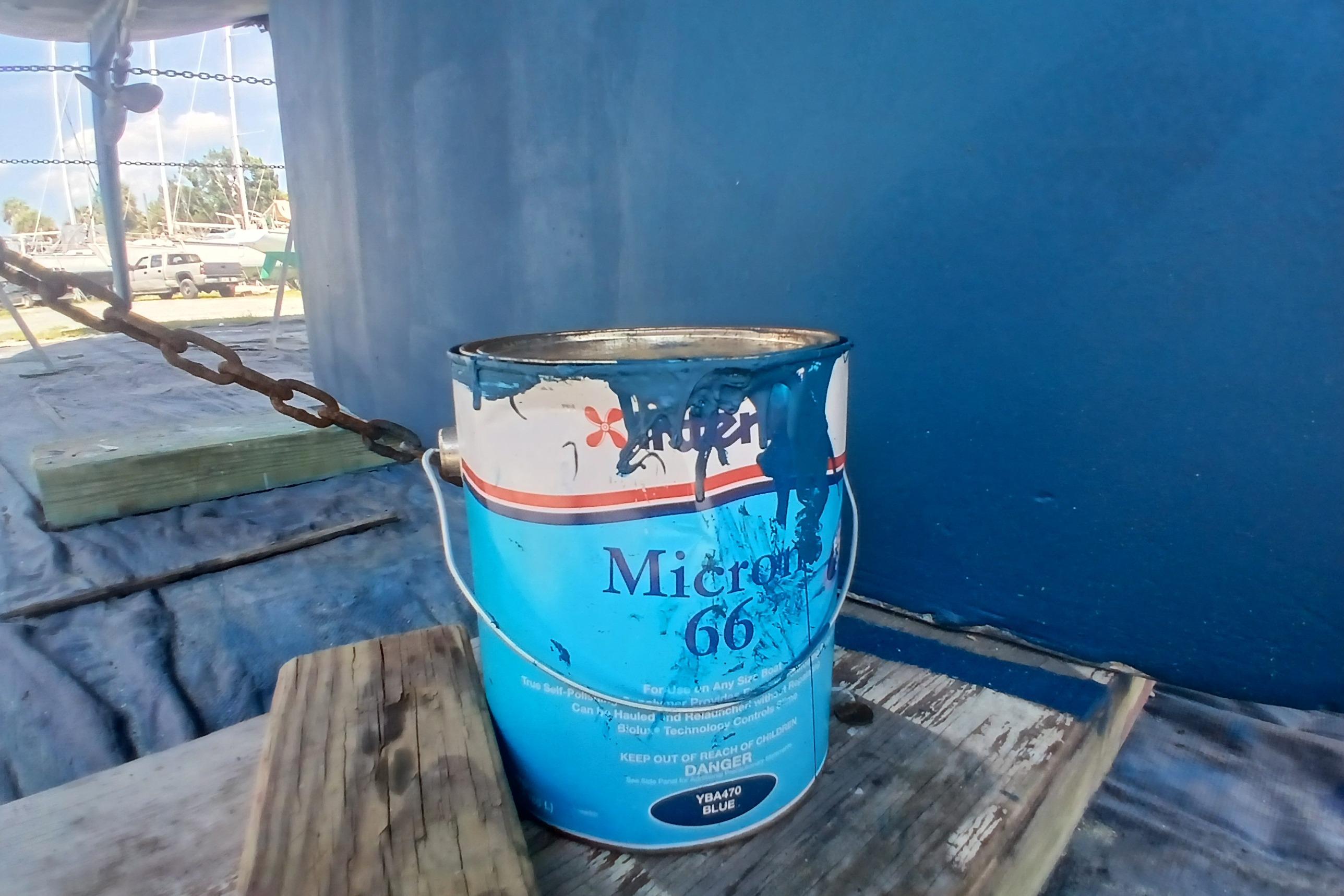 Paint can near a 1995 Catalina 42 MkII boat, with blue hull in background.