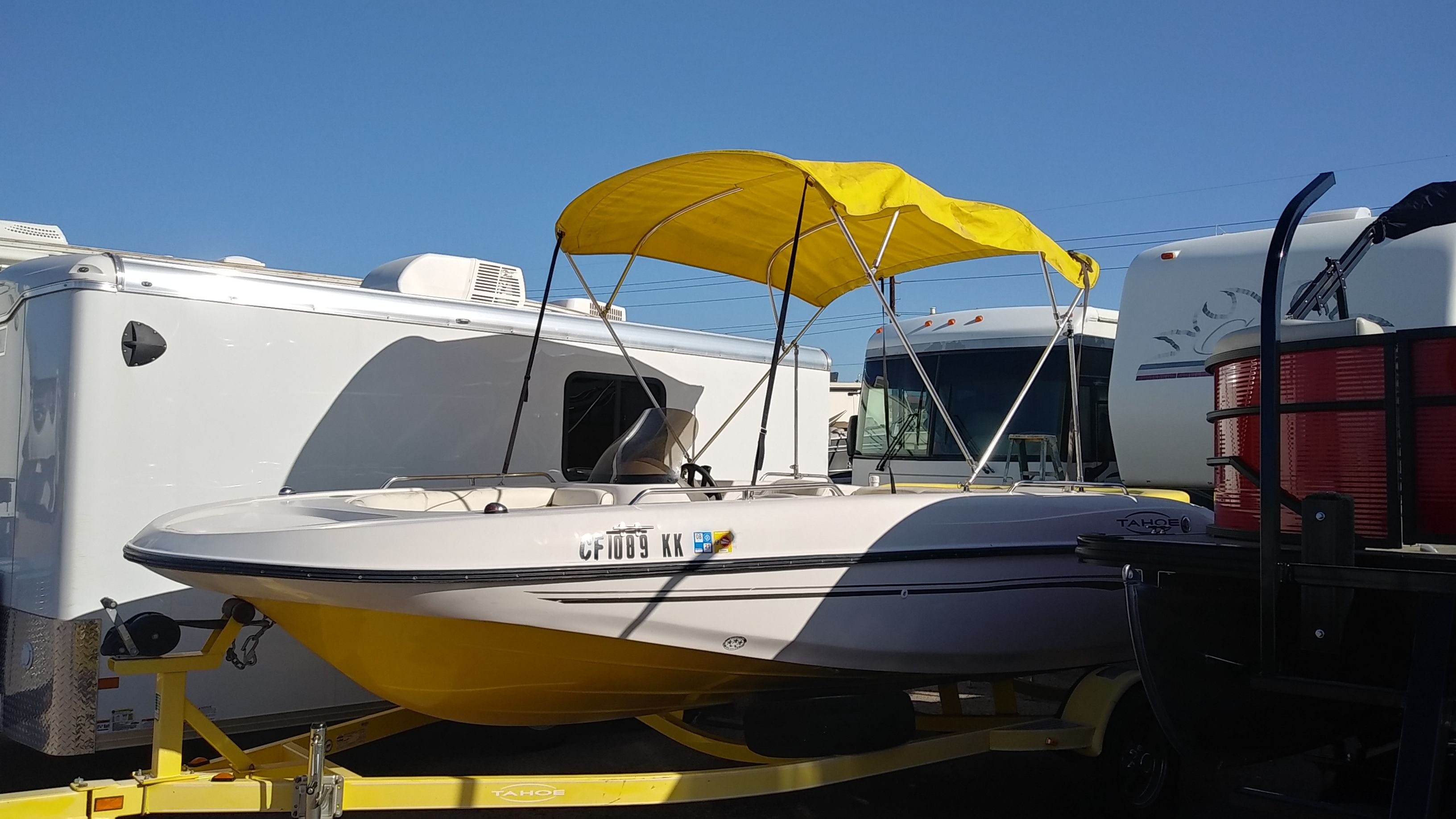 2004 Tracker Tahoe boat with yellow canopy on trailer.
