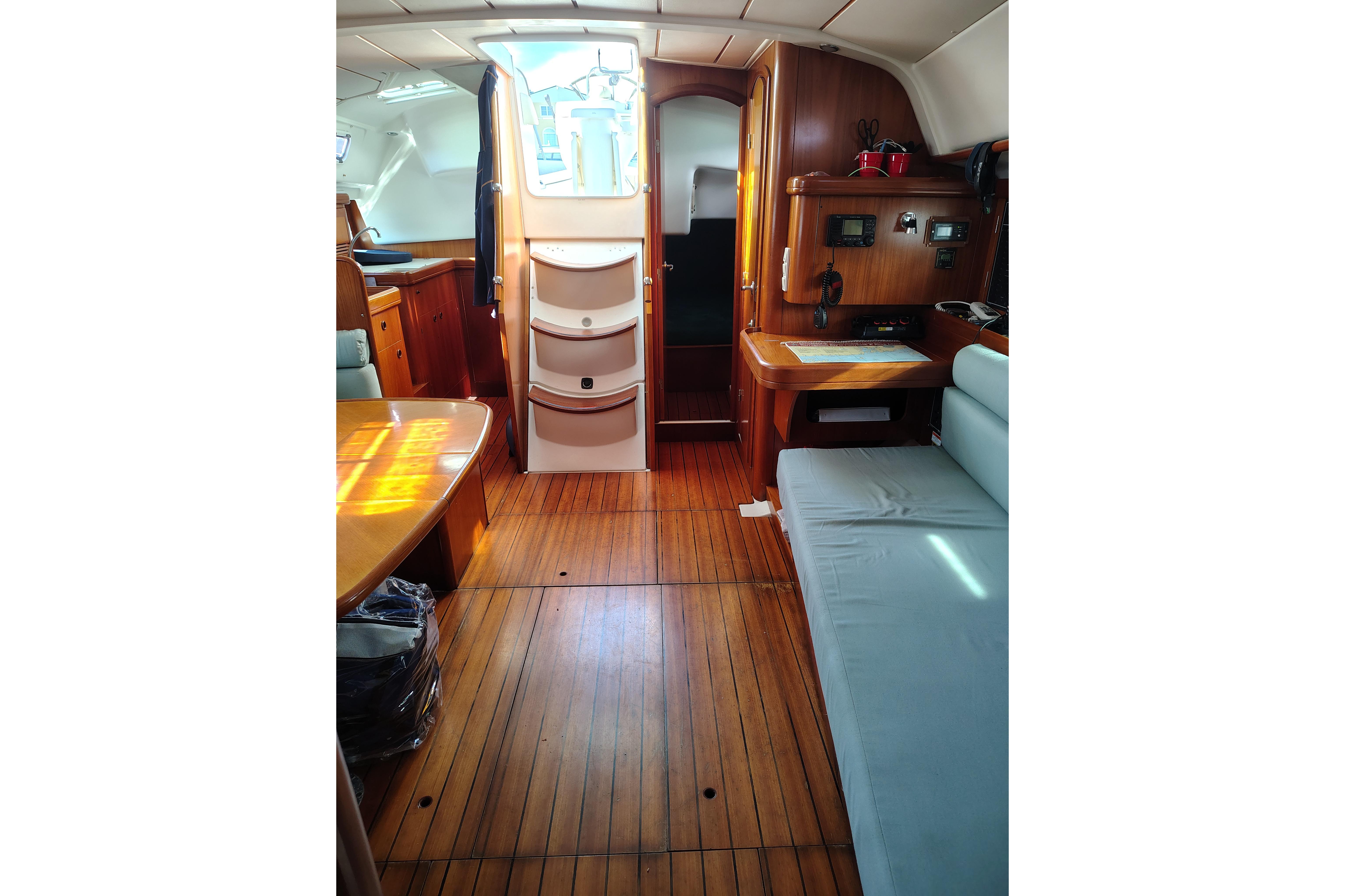 Interior of 2001 Beneteau Oceanis 411 sailboat with wooden flooring and seating area.