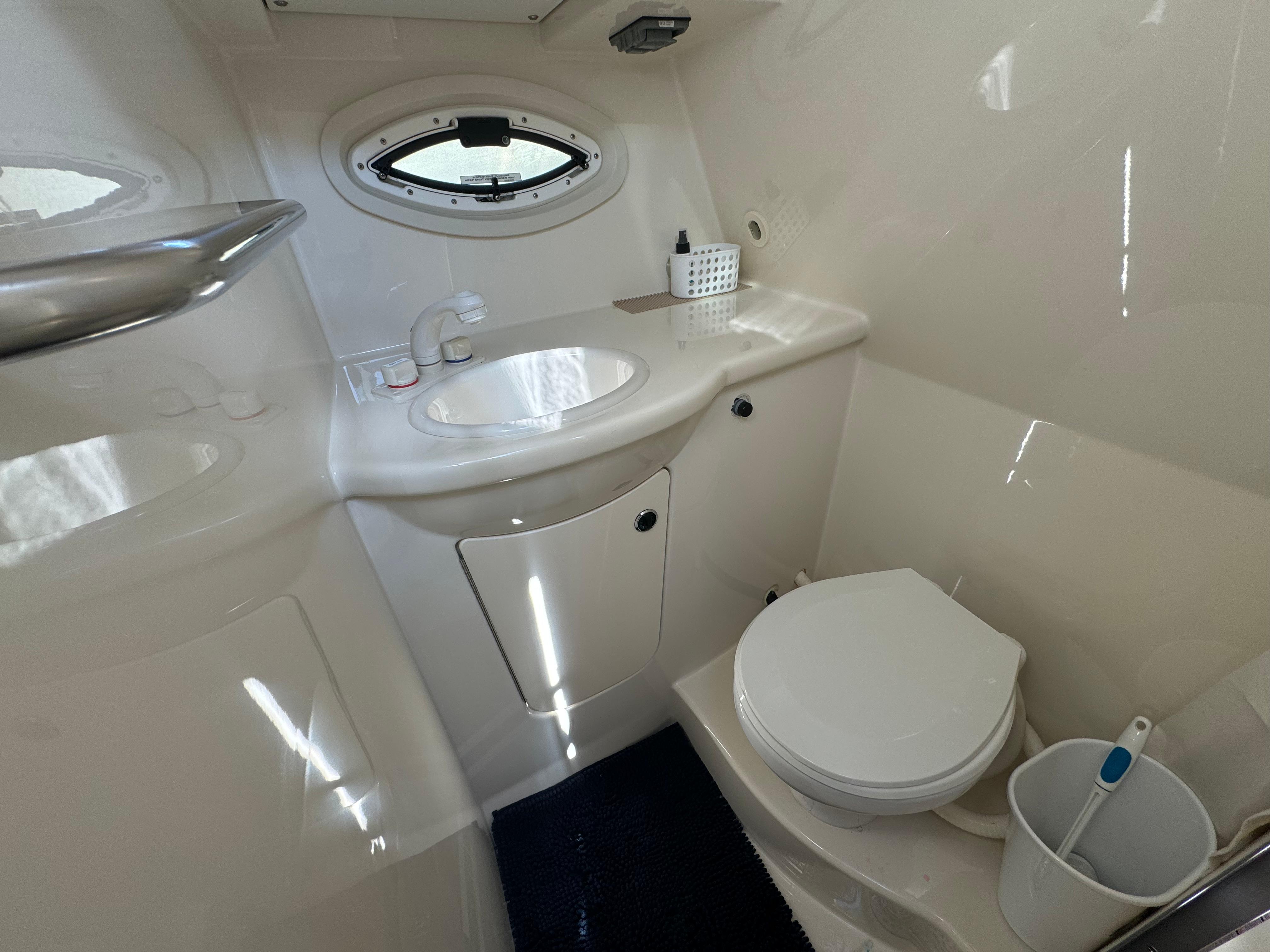 2008 Bayliner 300 Ciera bathroom with sink, toilet, and porthole window.