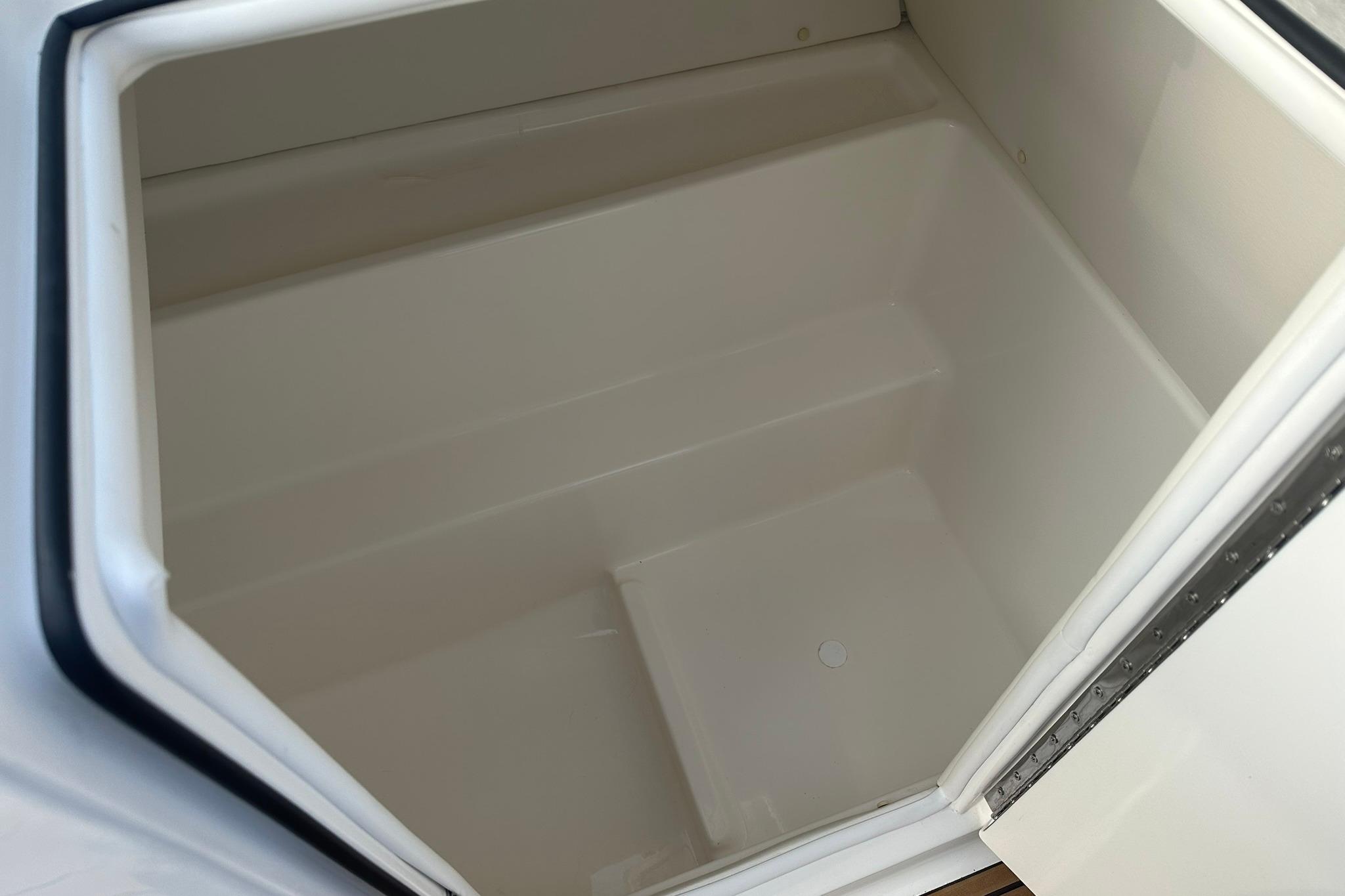 2026 Bayliner VR6 Bowrider OB storage compartment, open and empty.
