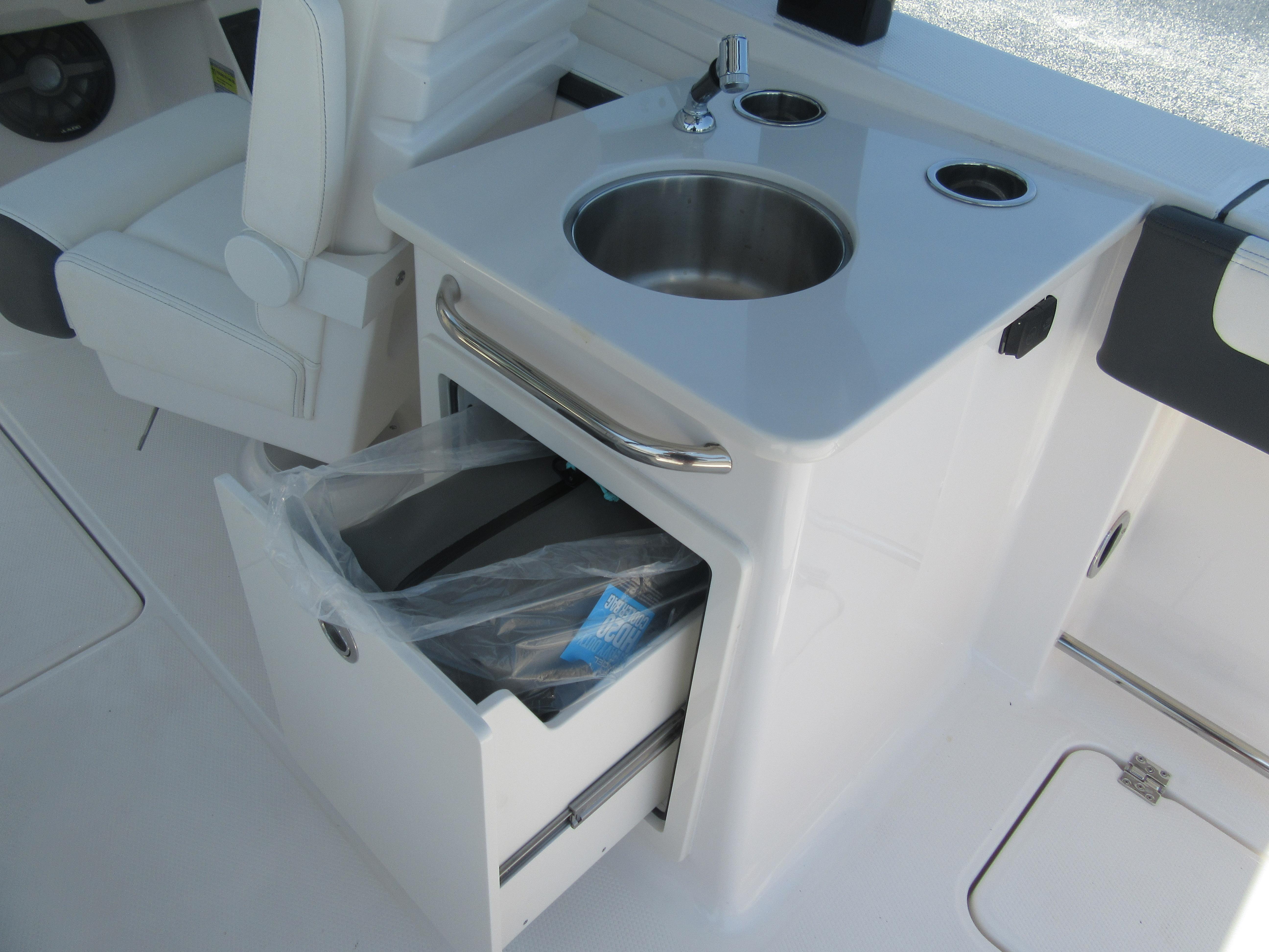 2025 Robalo R257 Dual Console boat interior with sink and storage drawer.