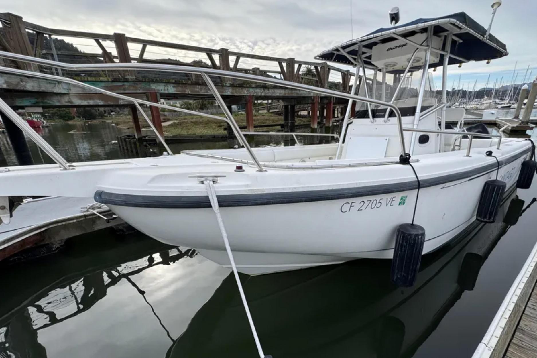 2001 Boston Whaler 26 Outrage boat docked in marina, side view.