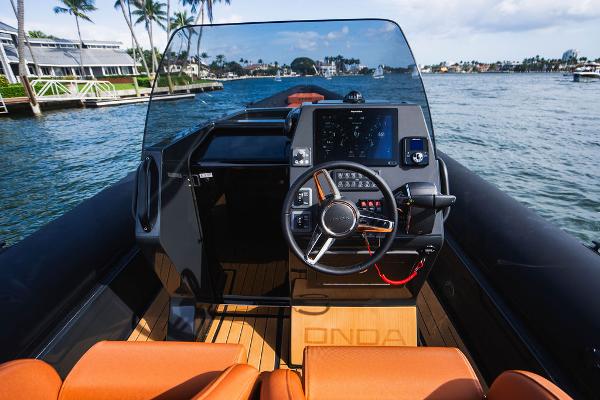 2024 Onda Magna boat cockpit with steering wheel and navigation system on a sunny day.