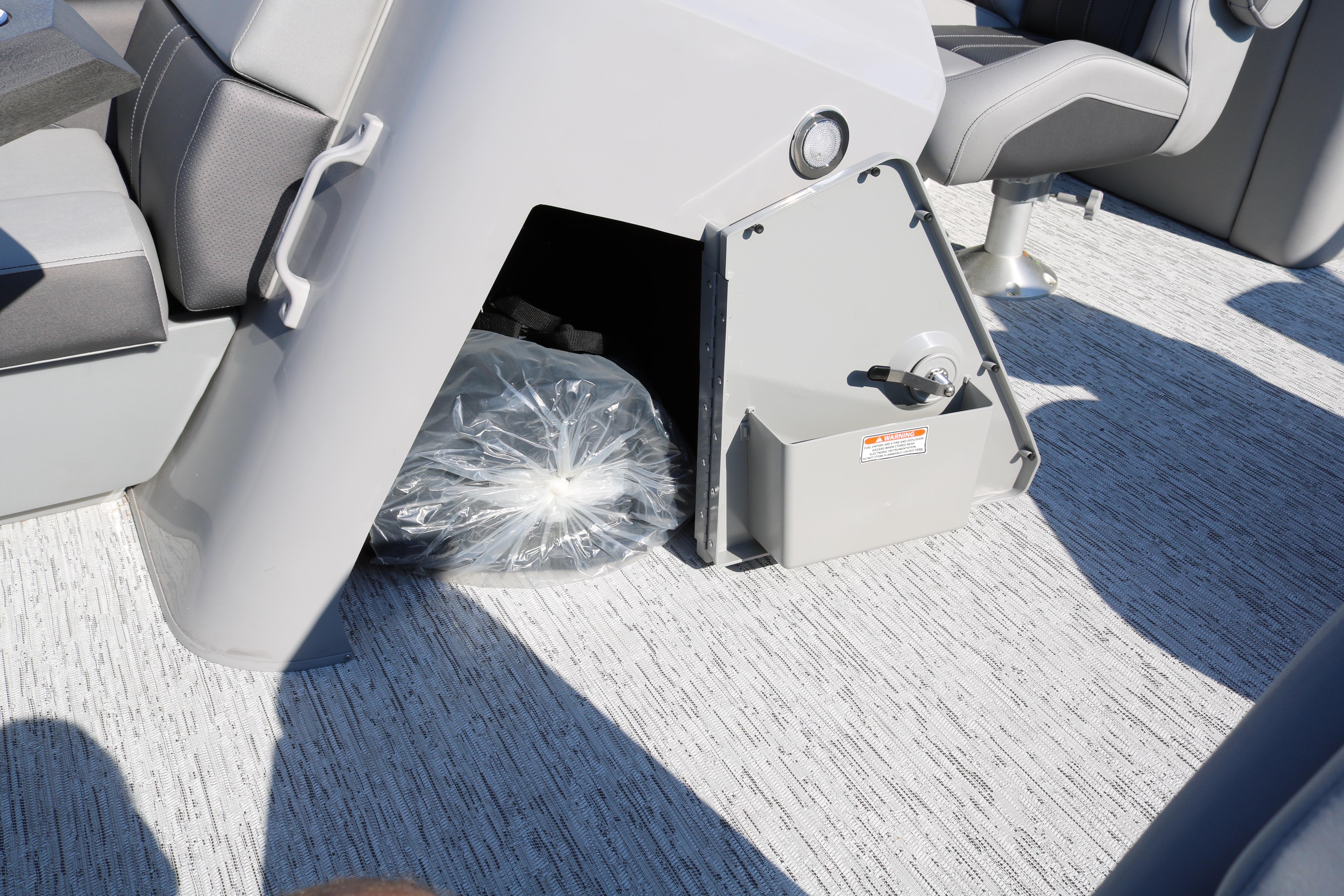 2026 Bennington 22SX Stern Radius boat interior storage compartment with gray seating.