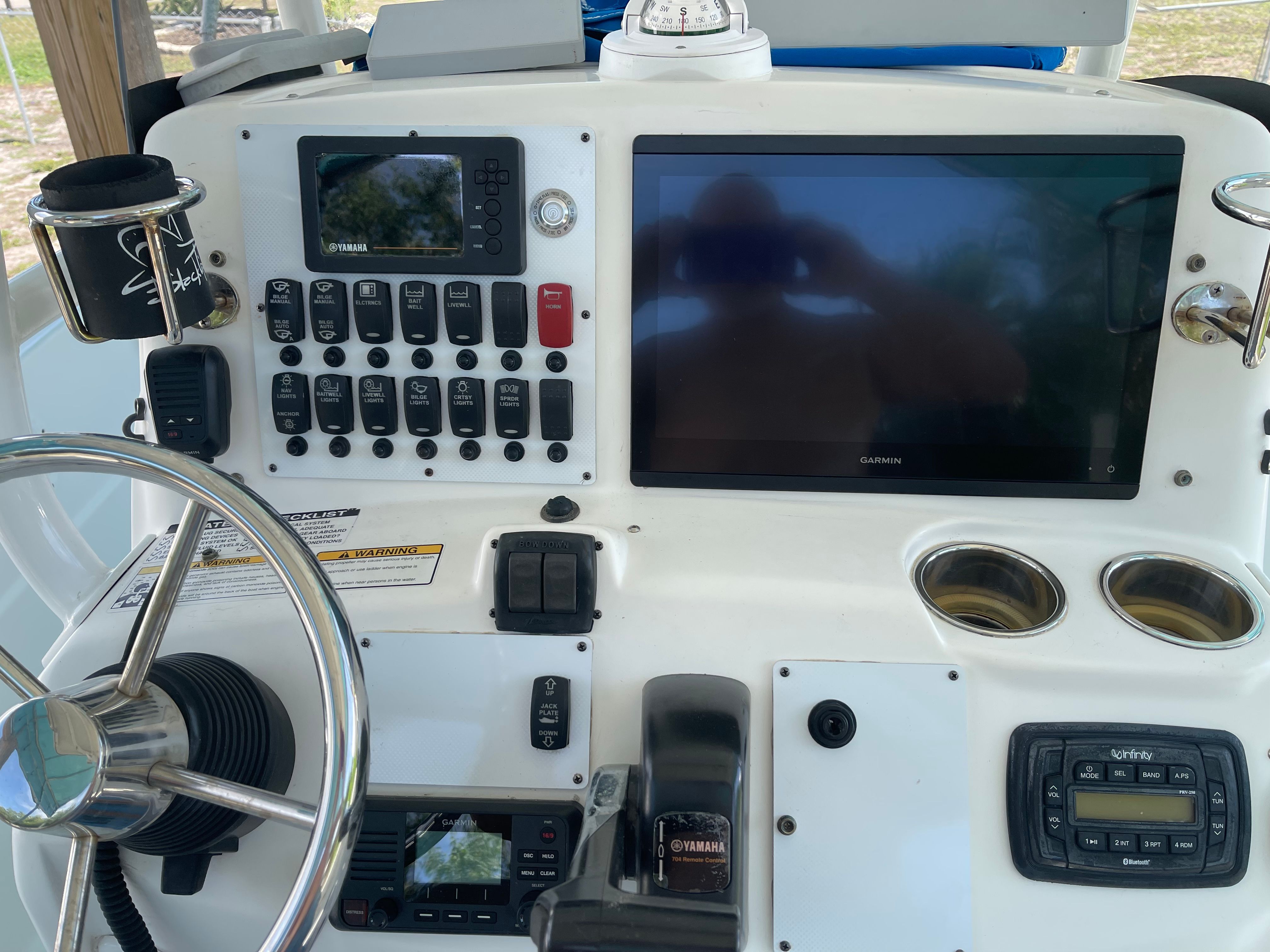 The image shows the helm of a 2015 NauticStar 231 Coastal boat with various instruments and screens.