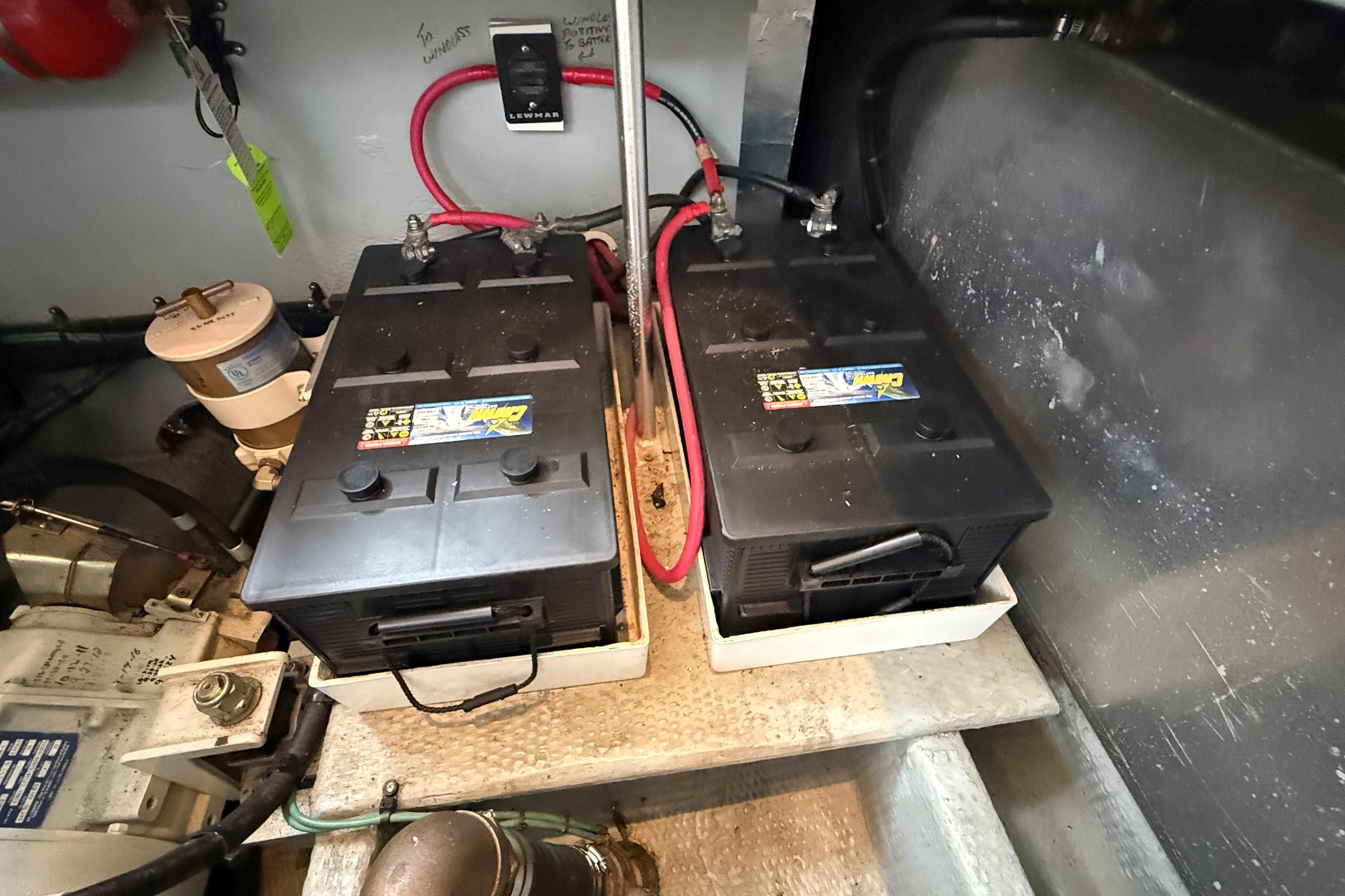Battery compartment of a 1999 Mainship 350 Trawler with dual batteries and wiring.