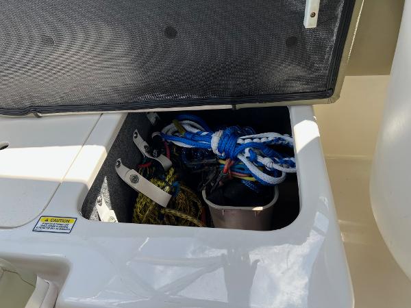 Storage compartment on a 2005 Sea Ray 220 Sundeck with ropes and equipment.