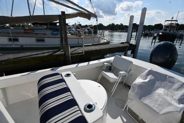 2021 Eastern 248 Center Console boat docked at a marina with seating and striped cushions.