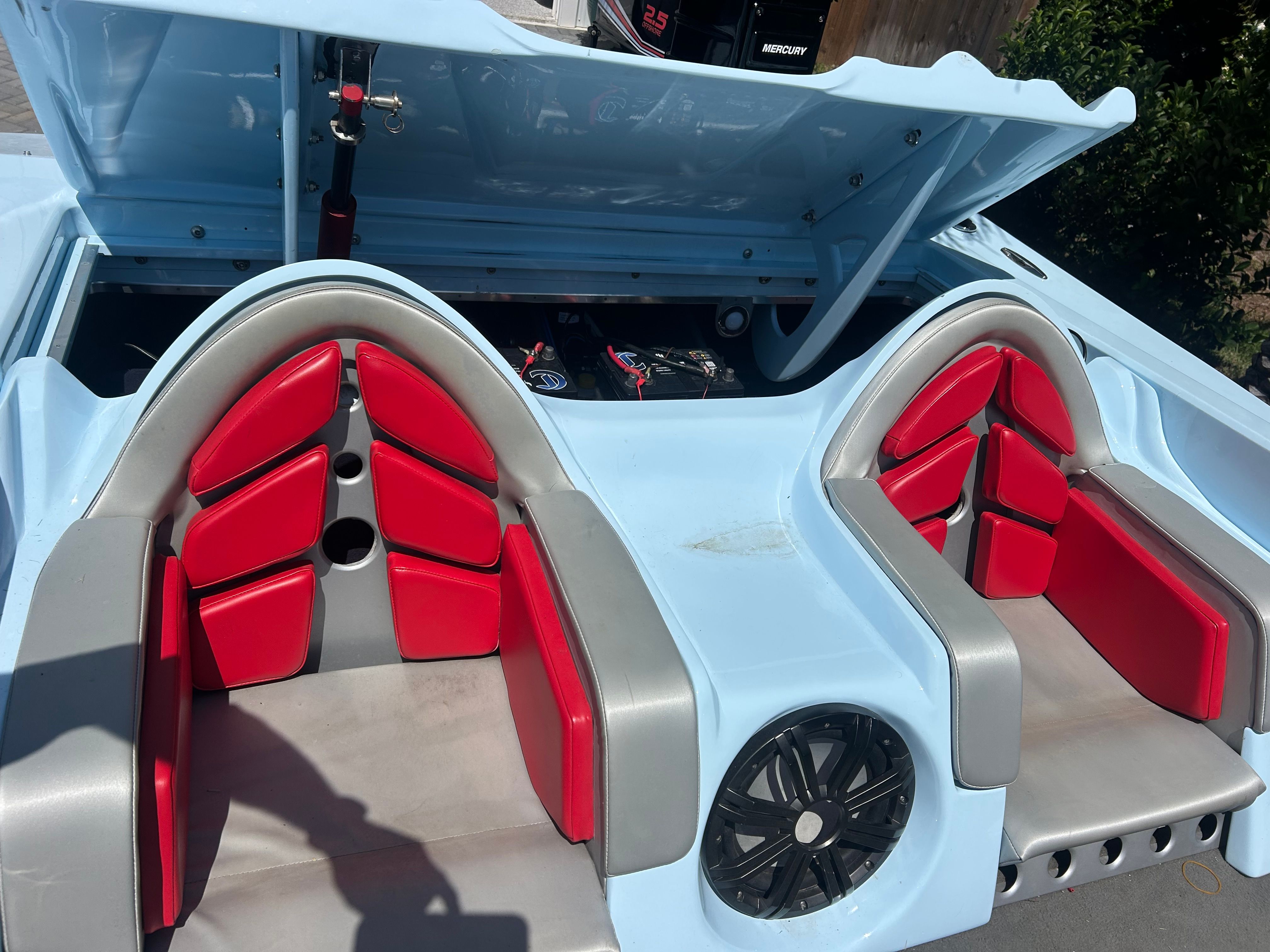 The image shows the cockpit of a 1992 Motion Marine 25 CAT with red seats.
