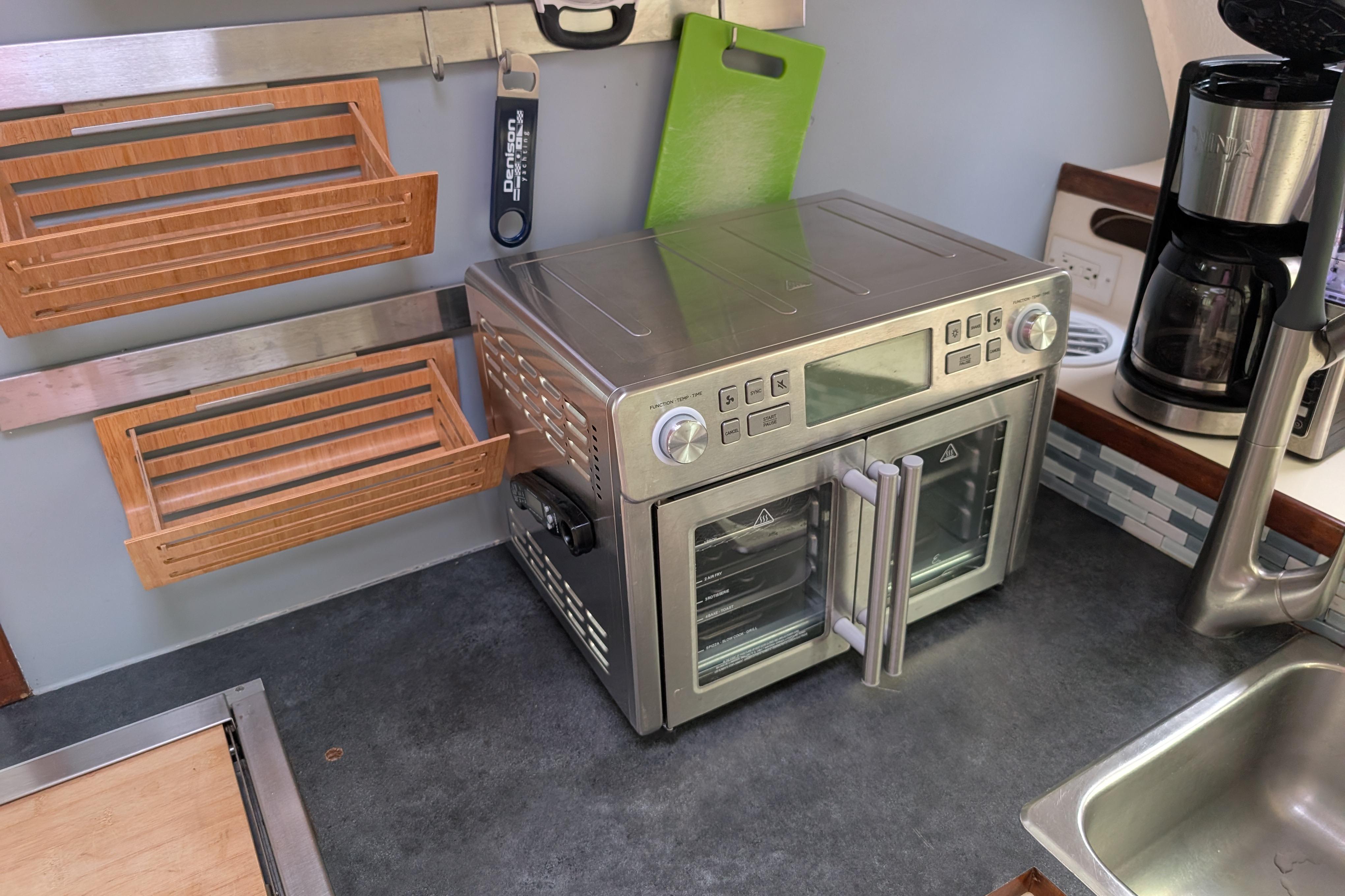 Modern kitchen setup on Island Spirit 37 yacht, featuring a stainless steel oven and coffee maker.