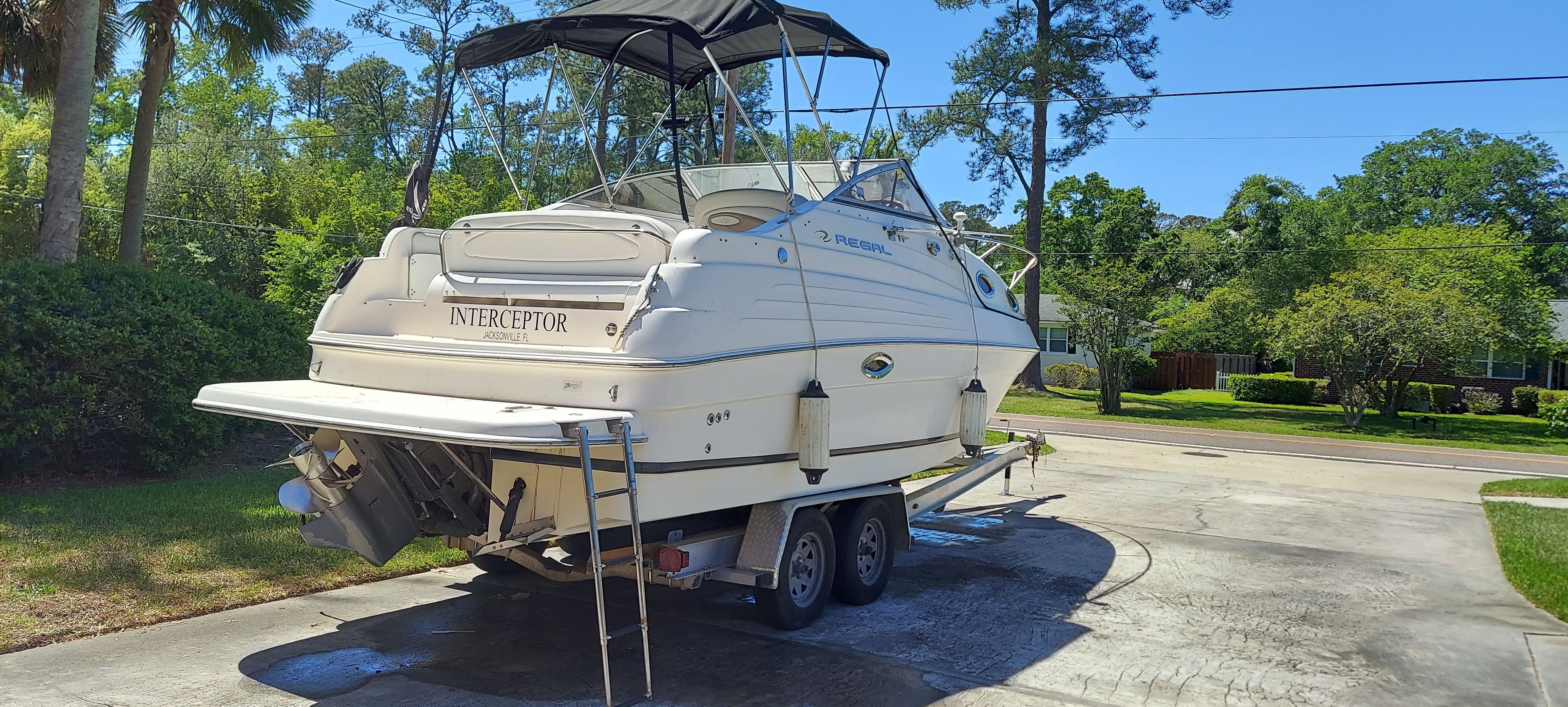 2004 Regal Commodore 2465 boat parked on trailer outdoors.