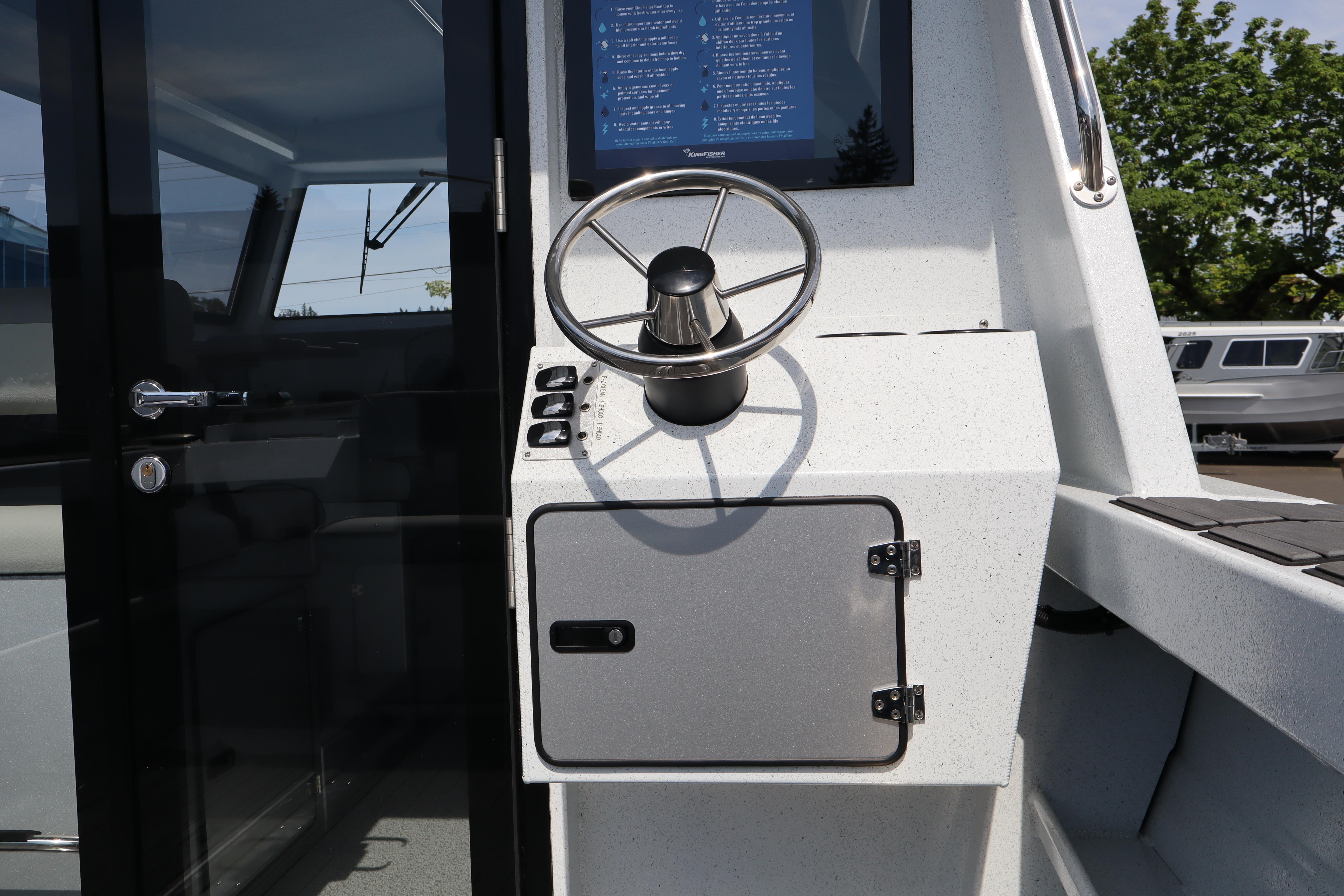 Steering console of 2026 KingFisher 25 XAC boat with modern controls and sleek design.