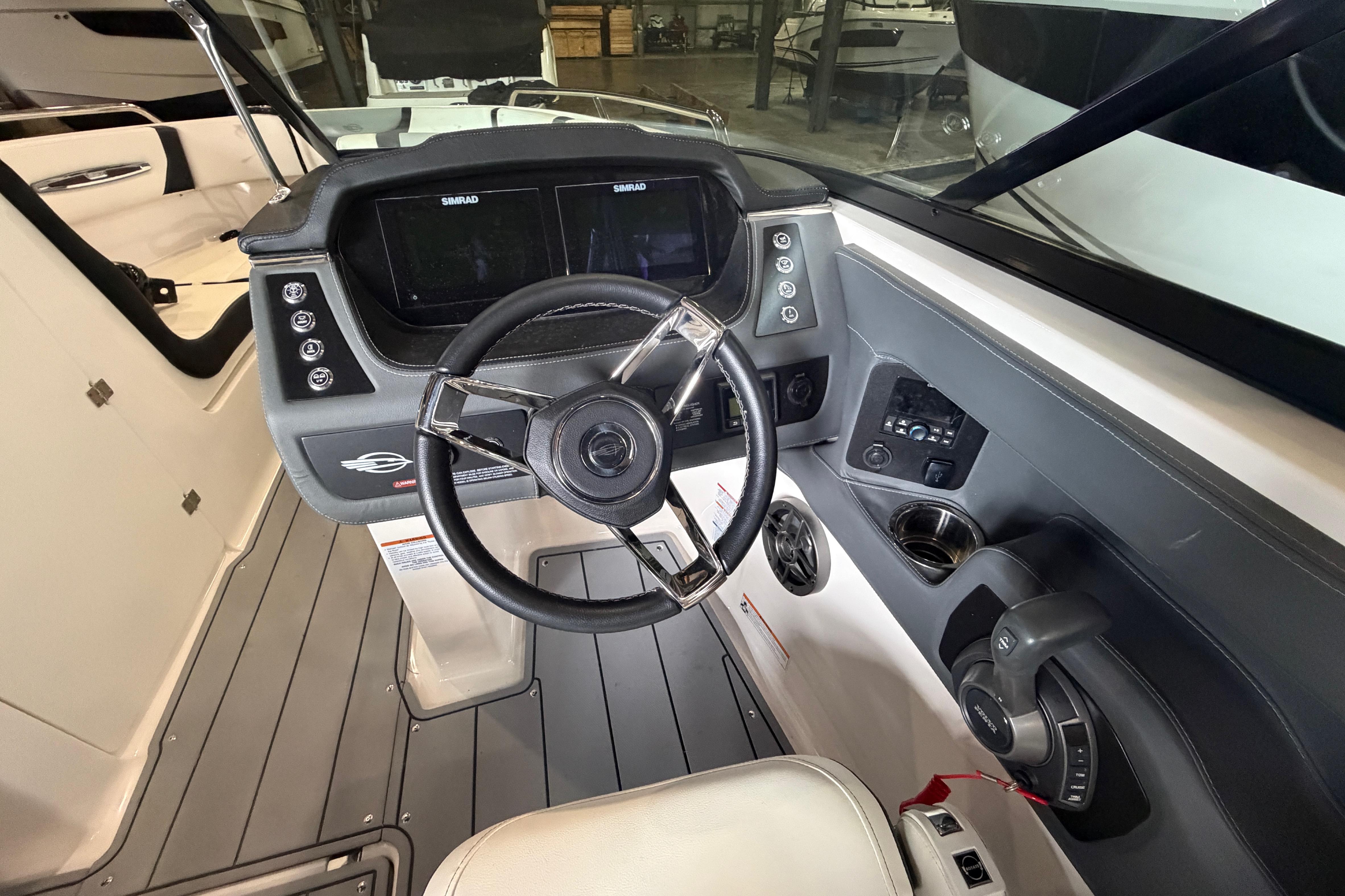 2023 Chaparral 247 SSX boat cockpit with steering wheel and control panel.