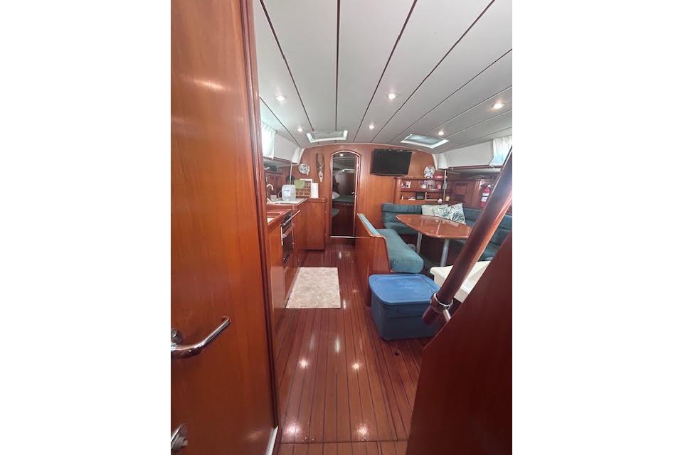 Interior of 2001 Beneteau Oceanis 461 yacht with wood finish and cozy seating area.