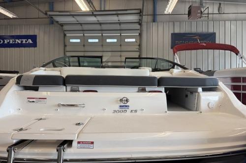 2027 Regal 2000 ES boat in showroom, rear view with seating and open garage door.
