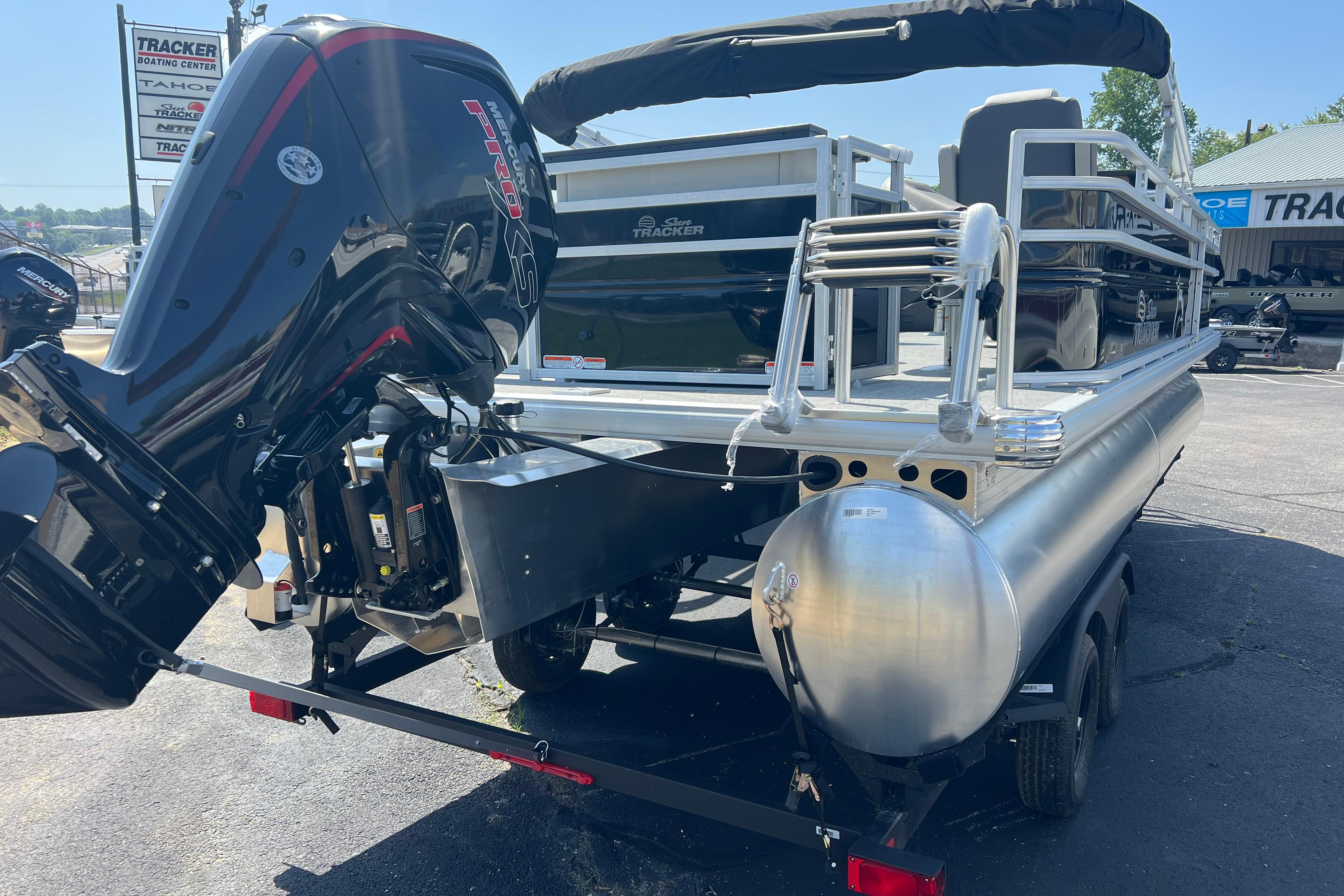 2026 Sun Tracker Fishin' Barge 22 DLX pontoon boat with powerful outboard motor.