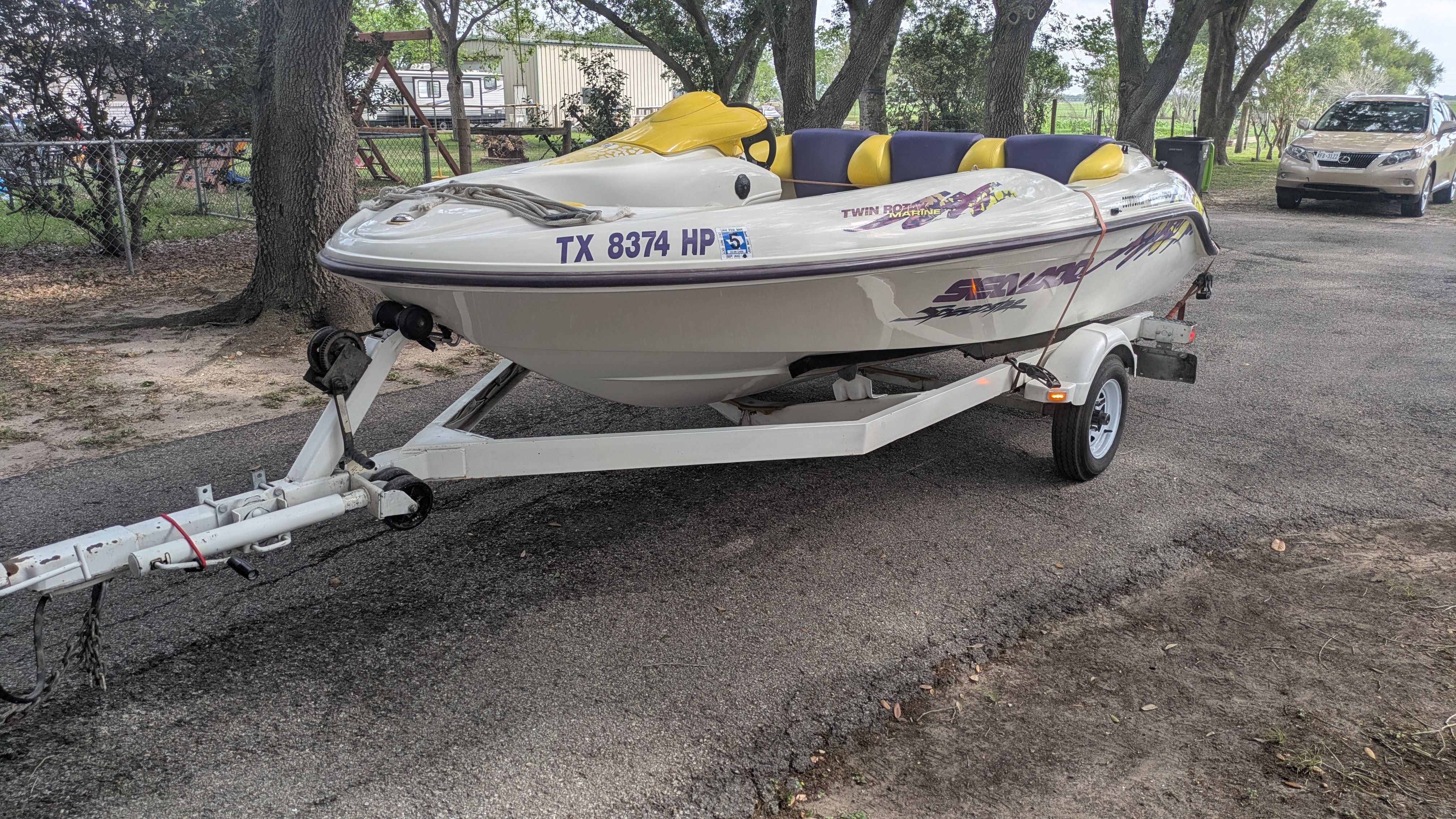 A white 1995 Bombardier SeaDoo SPEEDSTER boat on a trailer on a road.