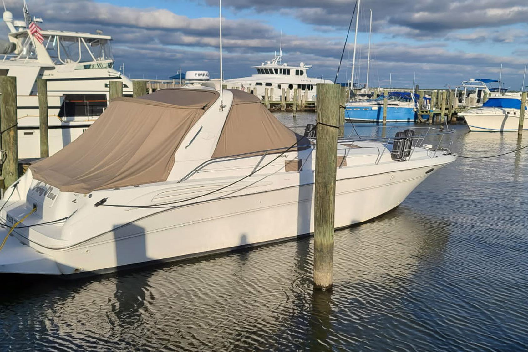 1998 Sea Ray Sundancer 400 yacht docked at marina under cloudy sky.