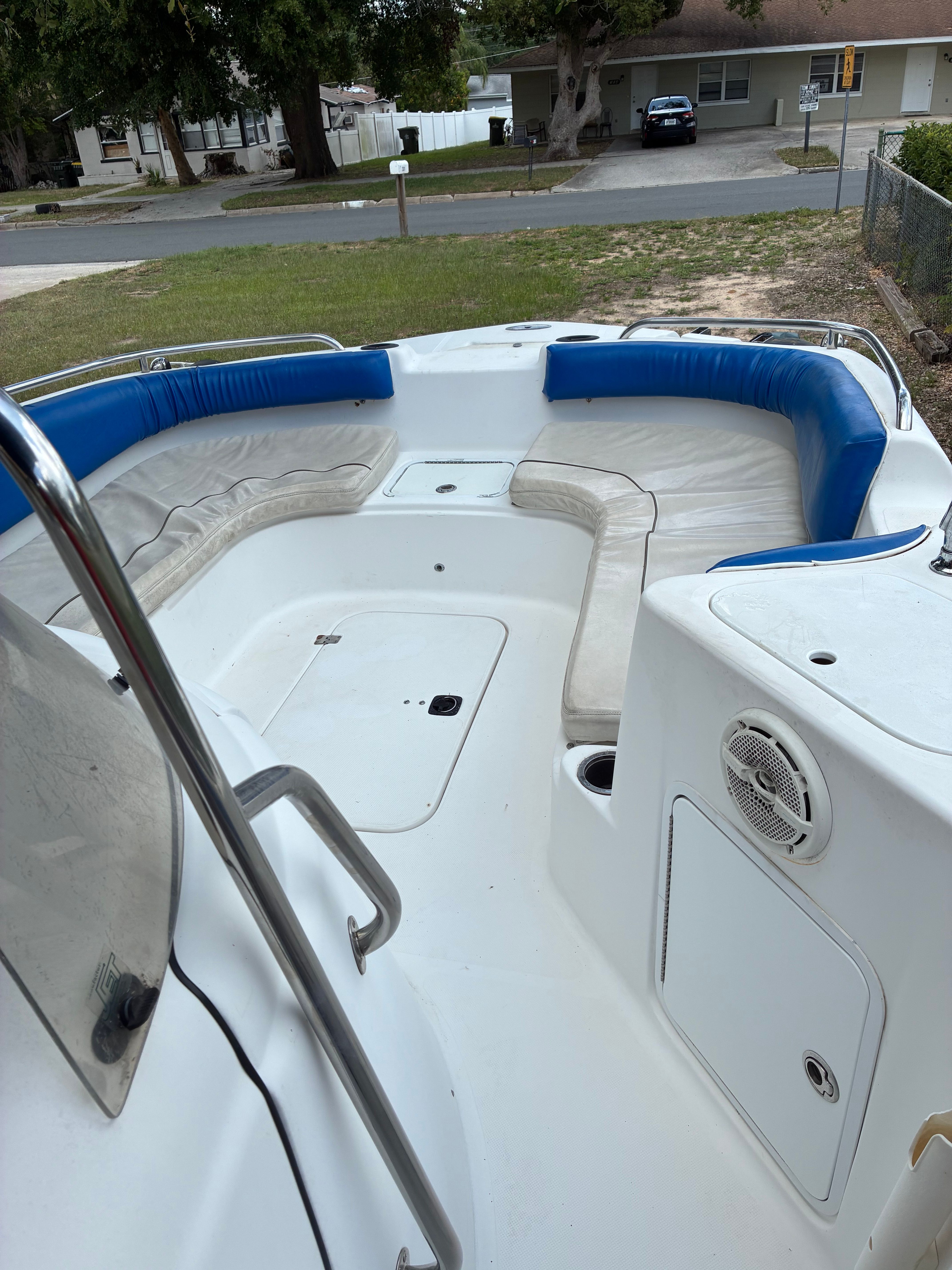 The image shows the cockpit of a Hurricane SunDeck Sport 231 OB boat with blue and white seating.