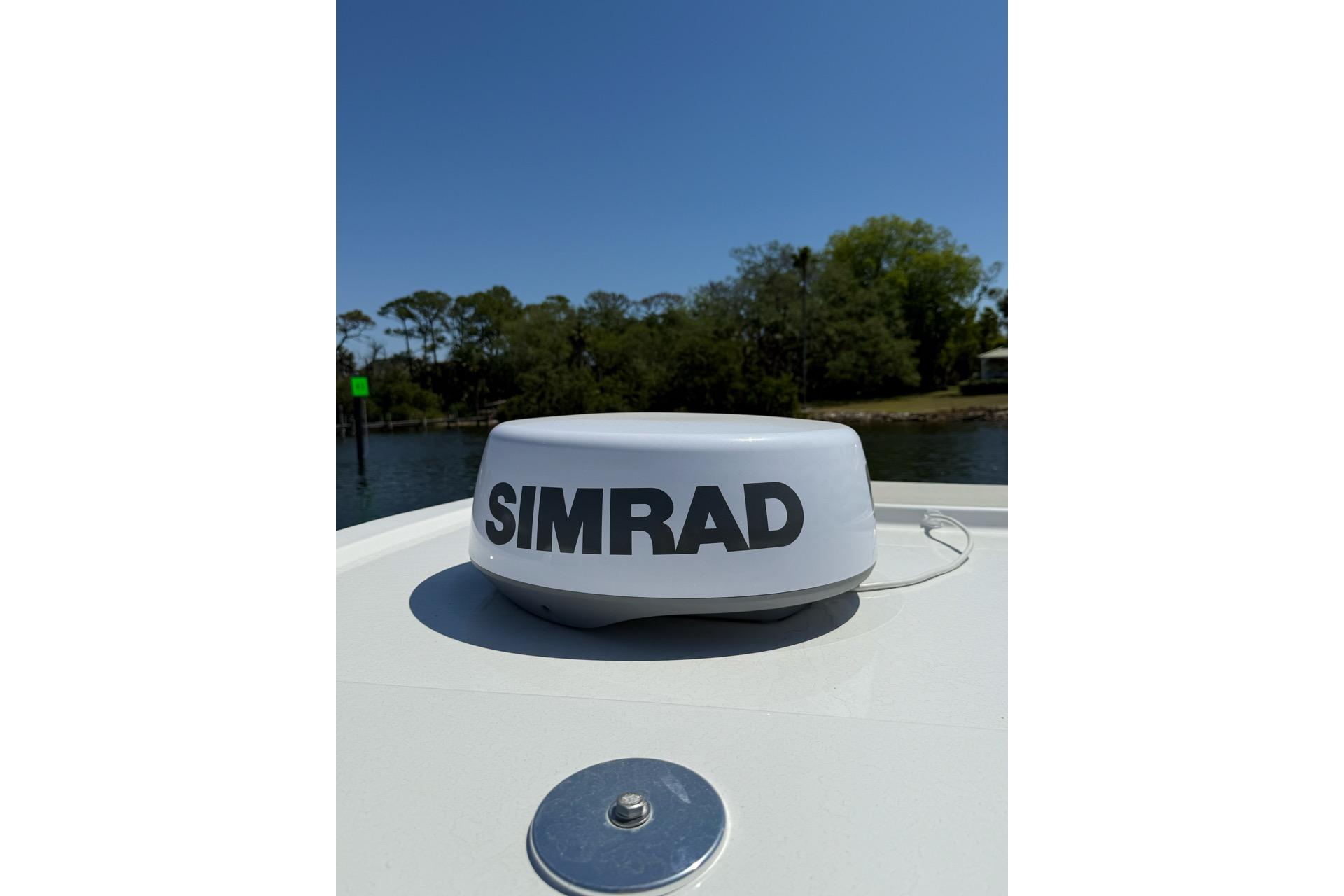 Simrad radar on 2021 Custom Infusion 34 CC boat, with scenic waterway background.